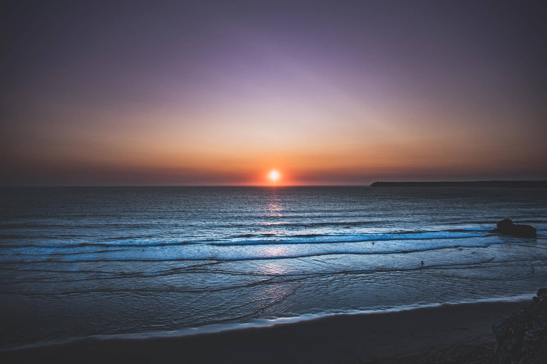 夕陽下的海洋，有溫柔的海浪和紫色橙色的天空