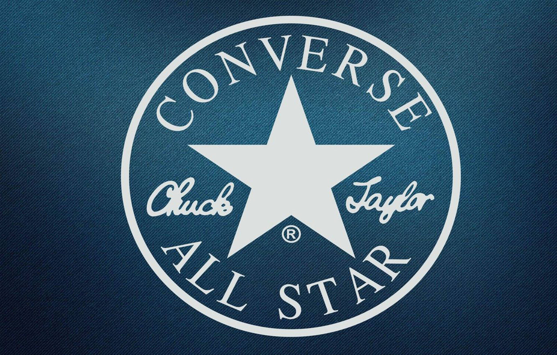 藍丹寧 Converse 標誌 壁紙 — 白色 Converse Chuck Taylor All Star 標誌在紋理深藍色牛仔布背景上。