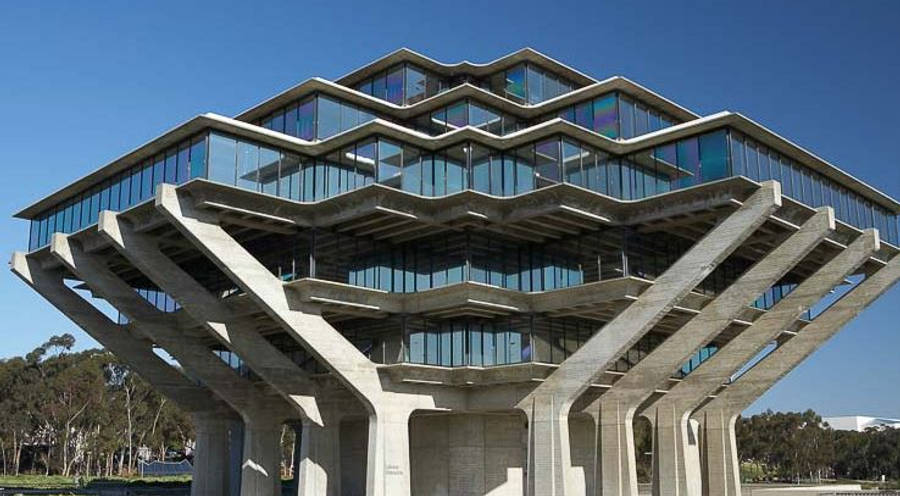 藍天下的 UCSD 建築 壁紙 — 一座引人注目的現代建築，擁有鋸齒狀混凝土陽台和玻璃牆，在清澈的藍天下。