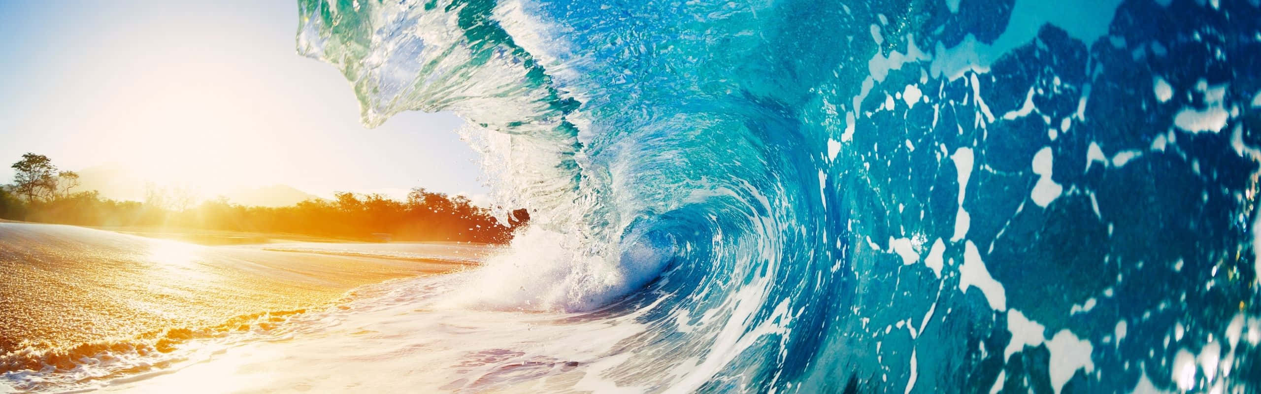 強勁的海浪在金色日出時拍打沙灘。