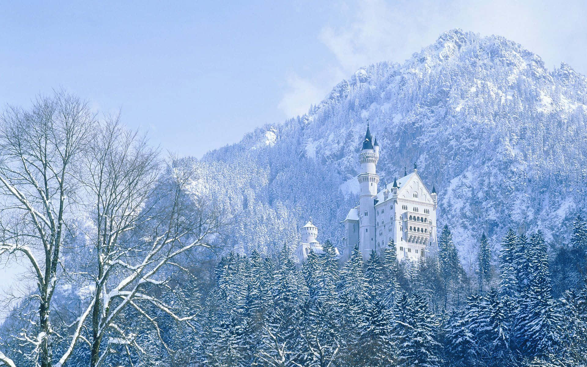 冬日森林中的雪城堡，背景是白雪覆蓋的山峰。