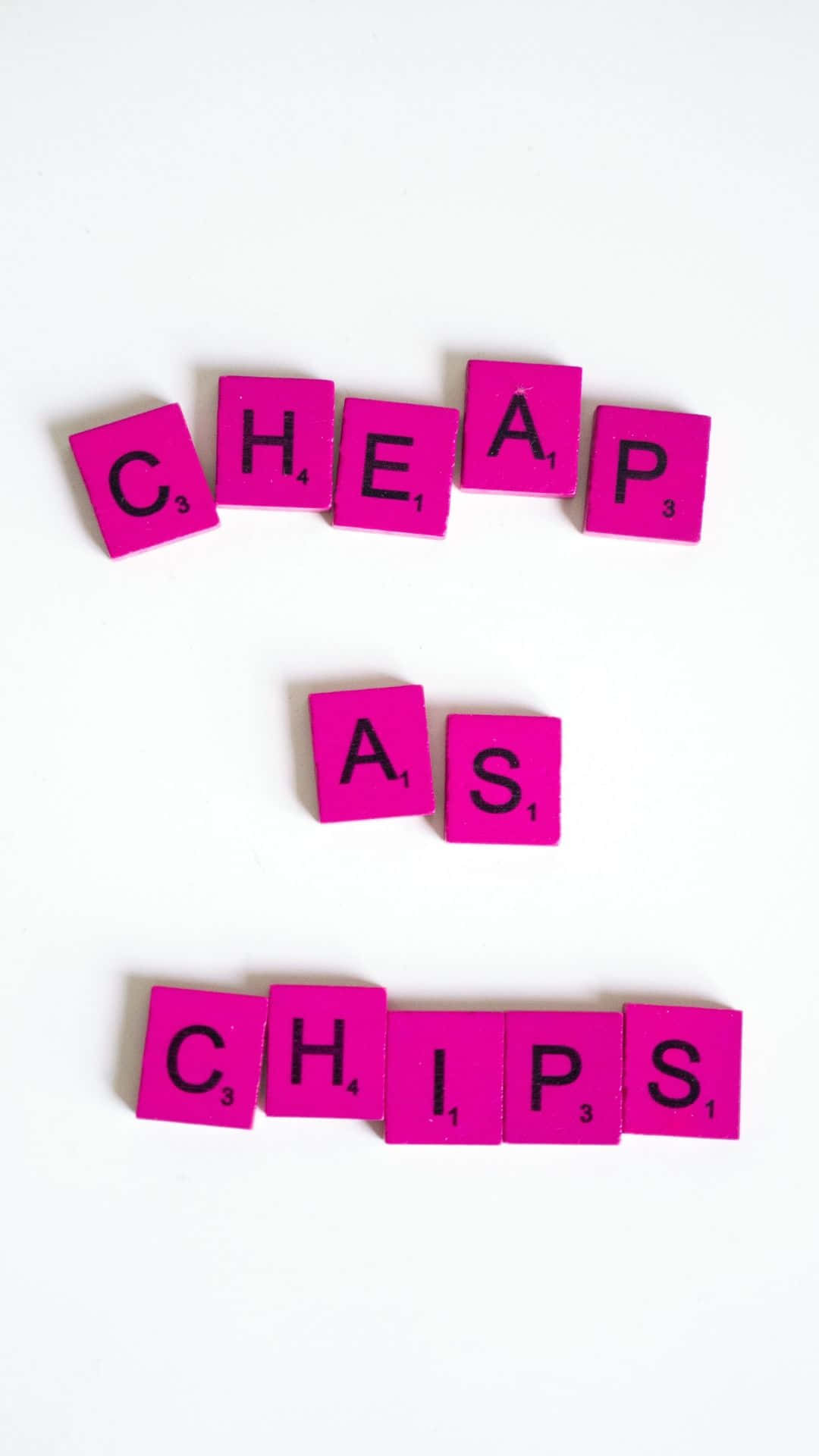 粉紅色Scrabble瓷磚在白色背景上拼出cheap as chips