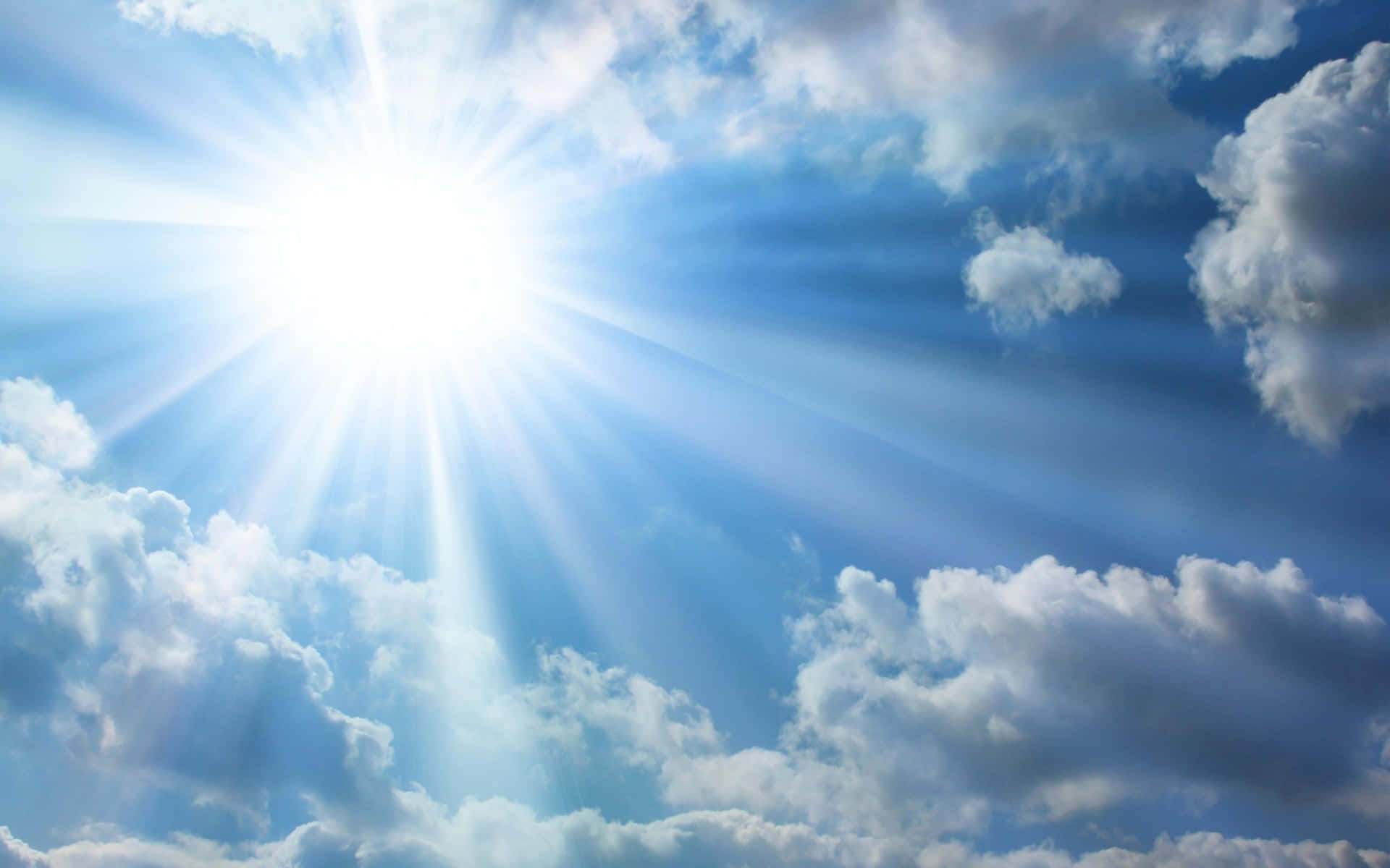 太陽穿過白雲在藍天中明亮地照耀。
