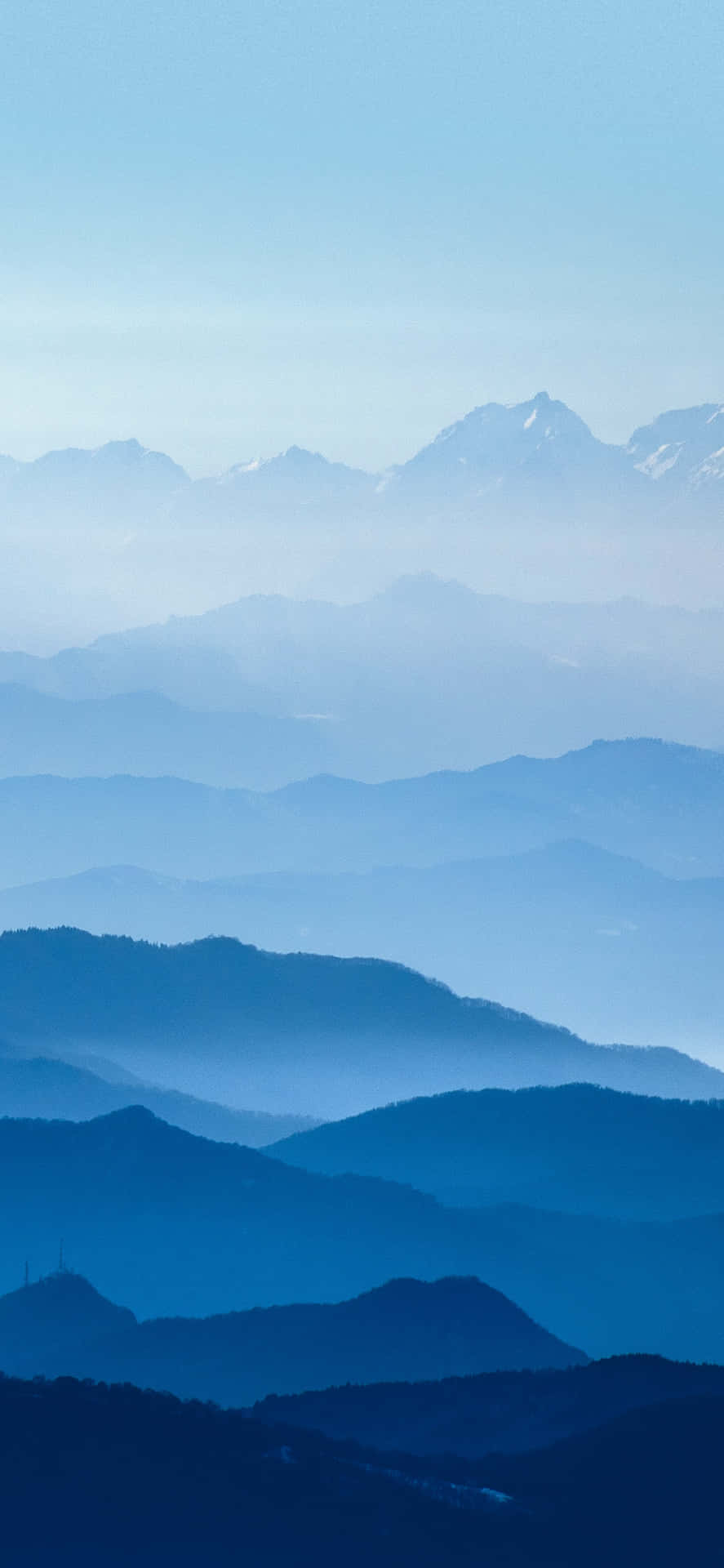 寧靜的山景，層層疊疊的山峰逐漸消失在藍色薄霧中。