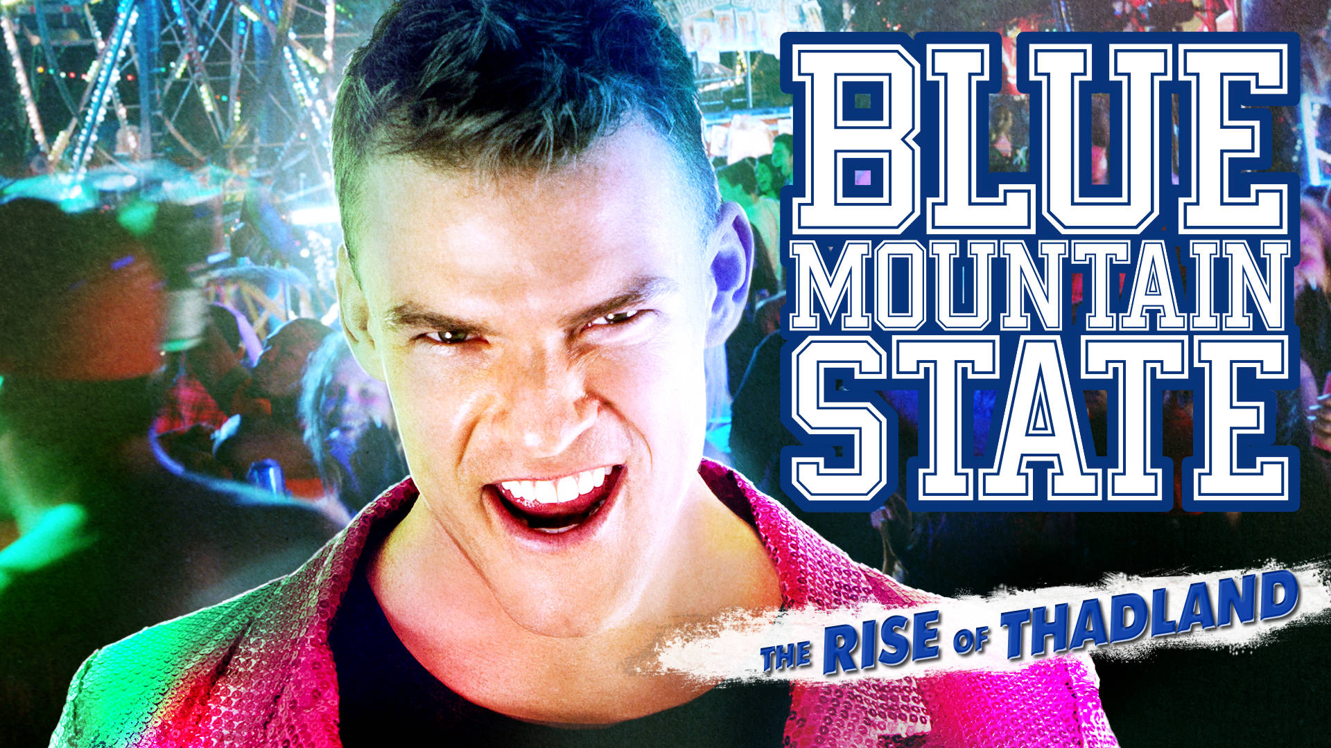 男子穿著粉紅色外套在夜間嘉年華上對著鏡頭微笑，帶有「Blue Mountain State」文字。
