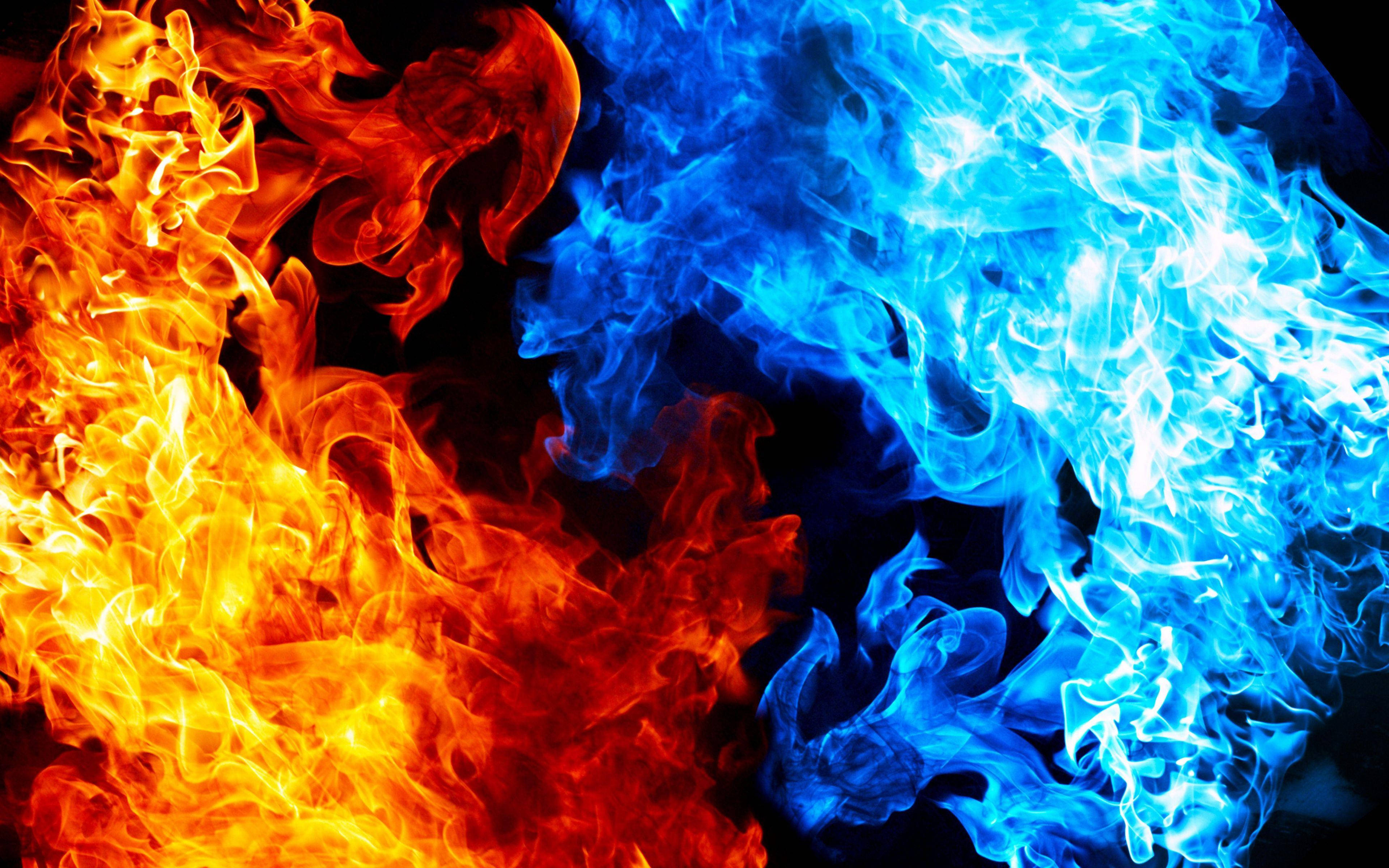 藍橙焰火之舞 壁紙 — 鮮豔的橙色和電光藍色火焰在黑色背景上動態碰撞，形成熾熱的抽象構圖。
