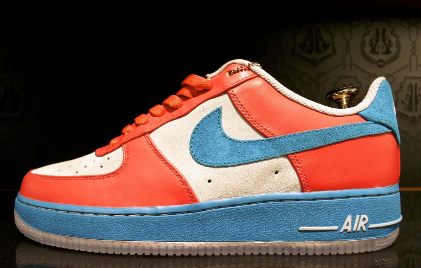 紅白藍Nike Air Force 1運動鞋，金色鞋跟標籤，深色背景。