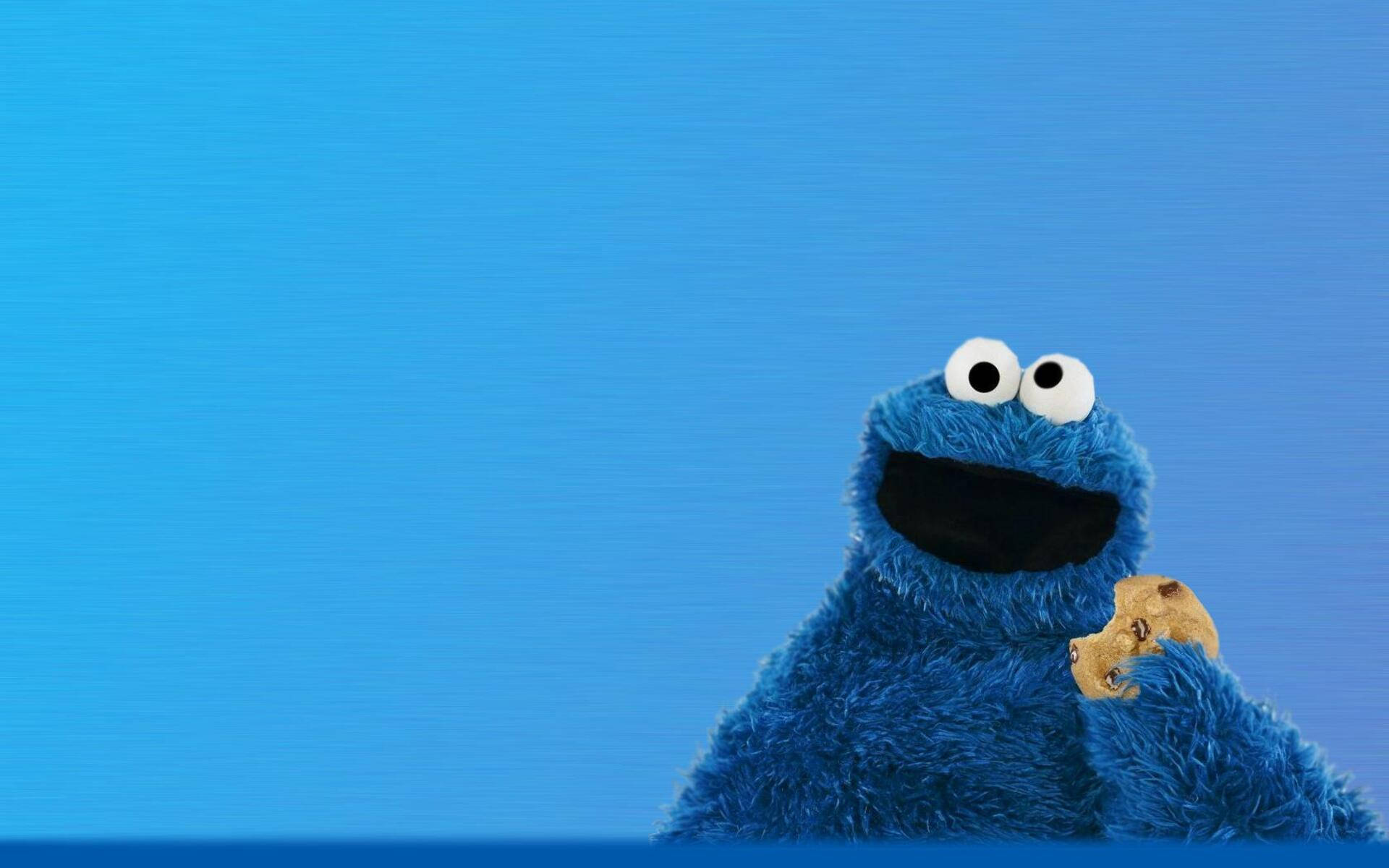 Cookie Monster 在藍色背景上拿著一塊餅乾。