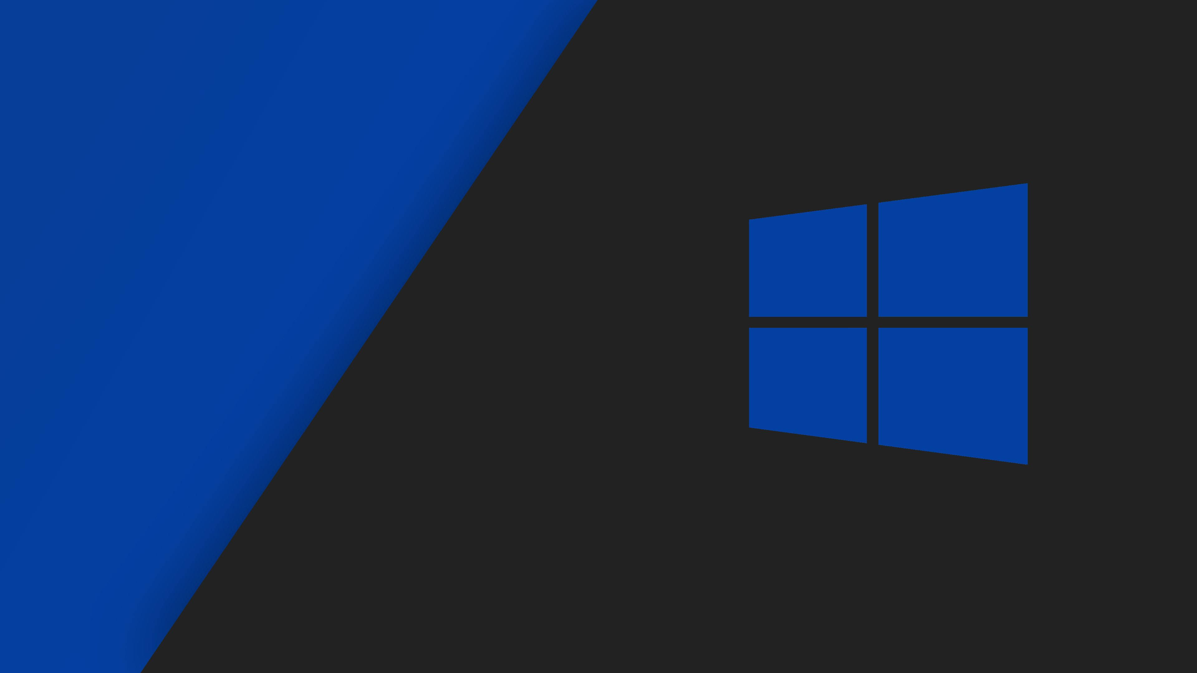 藍灰 Windows 10 壁紙 — 一個極簡的數碼牆紙，在深色背景上帶有藍色Windows標誌和對角藍色漸變。