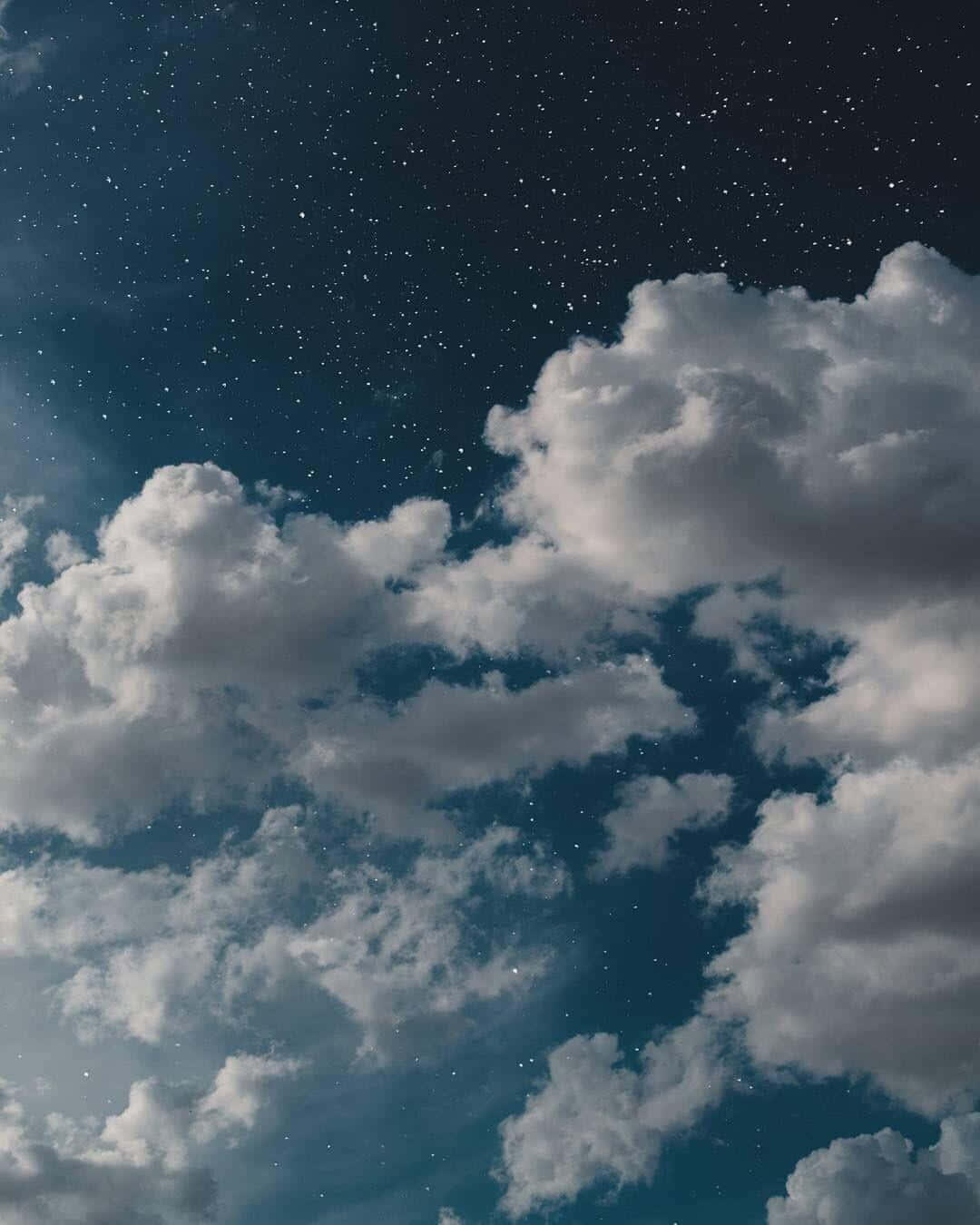 星空夜空，蓬鬆的白雲襯托著深藍色背景