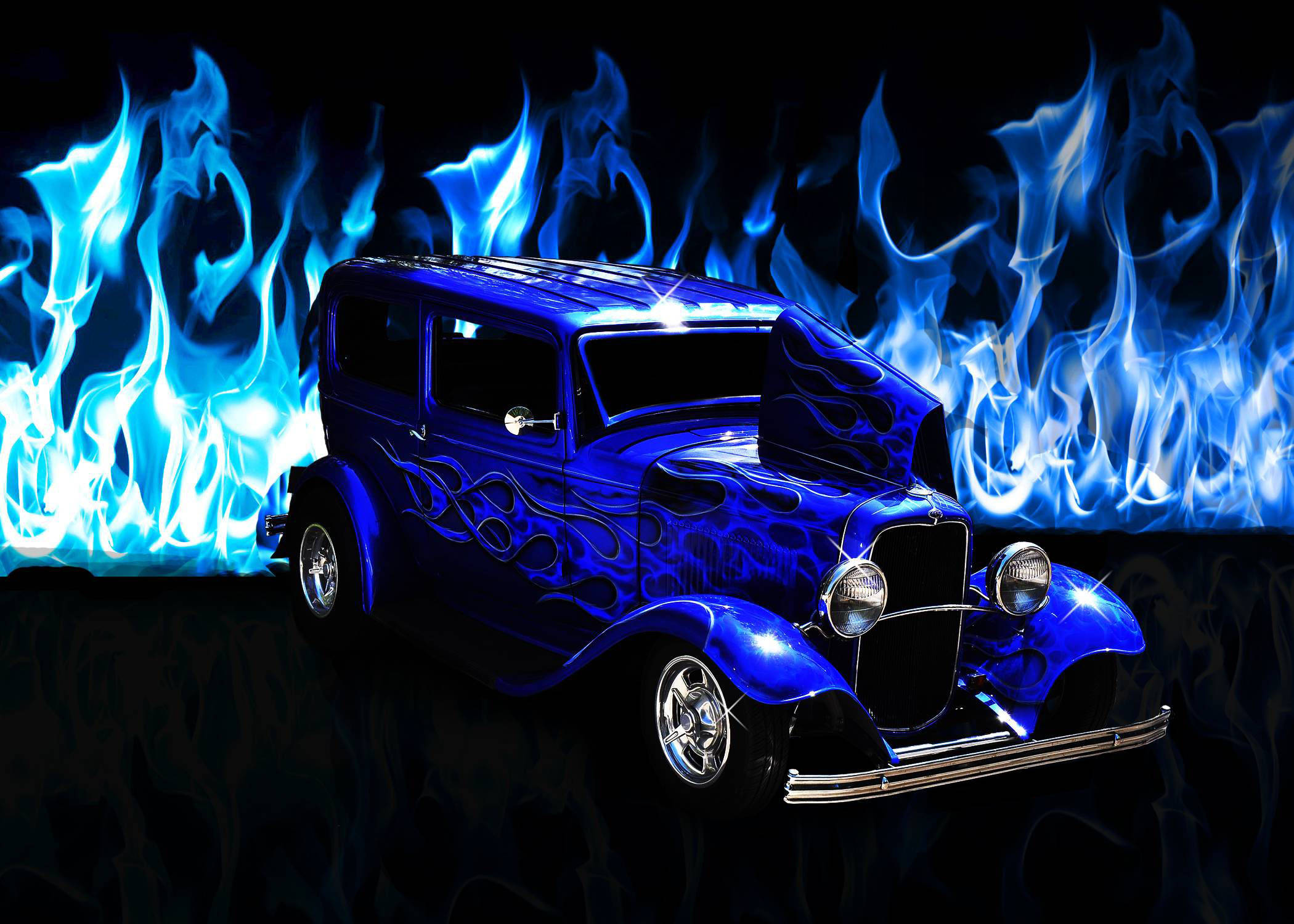 藍焰包覆經典福特車 壁紙 — 一輛帶有火焰貼花的亮藍色熱棒車，在黑色背景前，立於電藍色火焰之前。