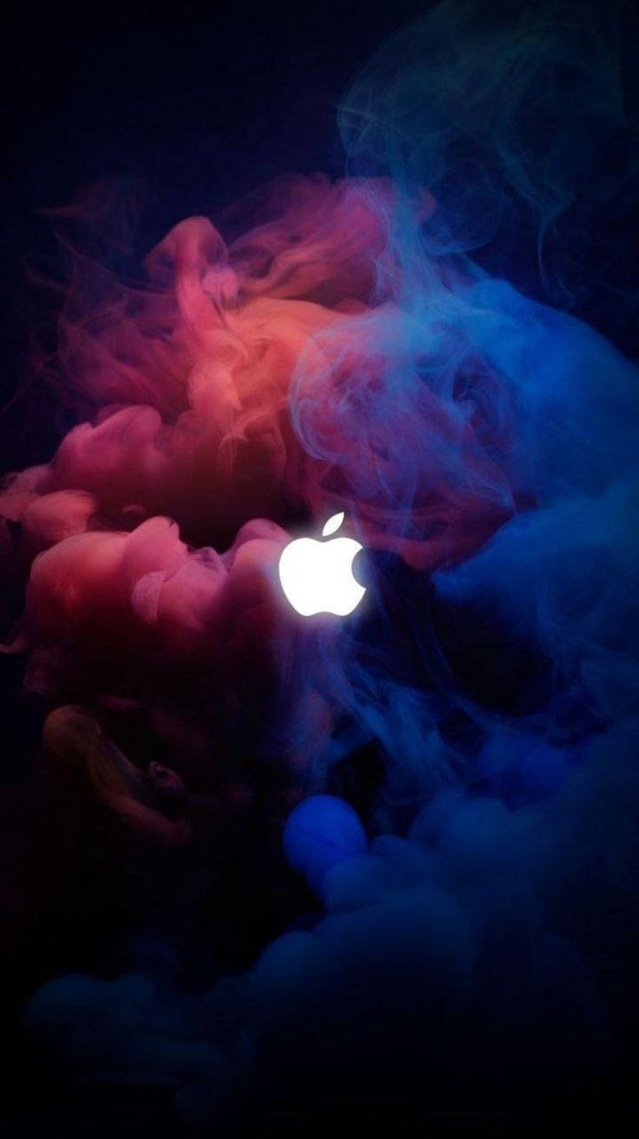 發光的Apple標誌在黑暗中環繞著紅色和藍色煙霧