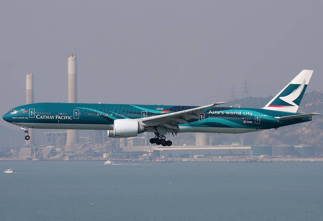 國泰航空飛機在工業煙囪附近的水面上降落。