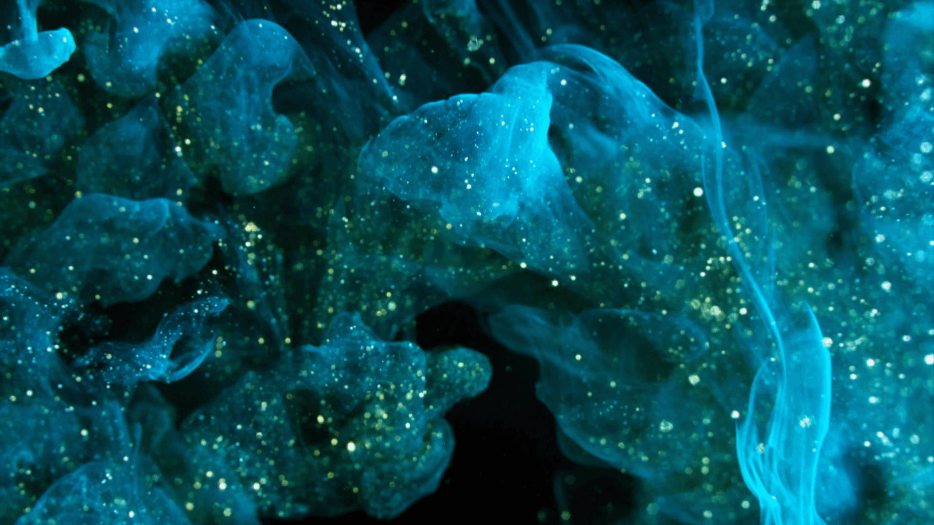藍綠色星際美學 壁紙 — 充滿活力的綠松石色煙霧與金色閃粉顆粒在深黑色背景上旋轉。