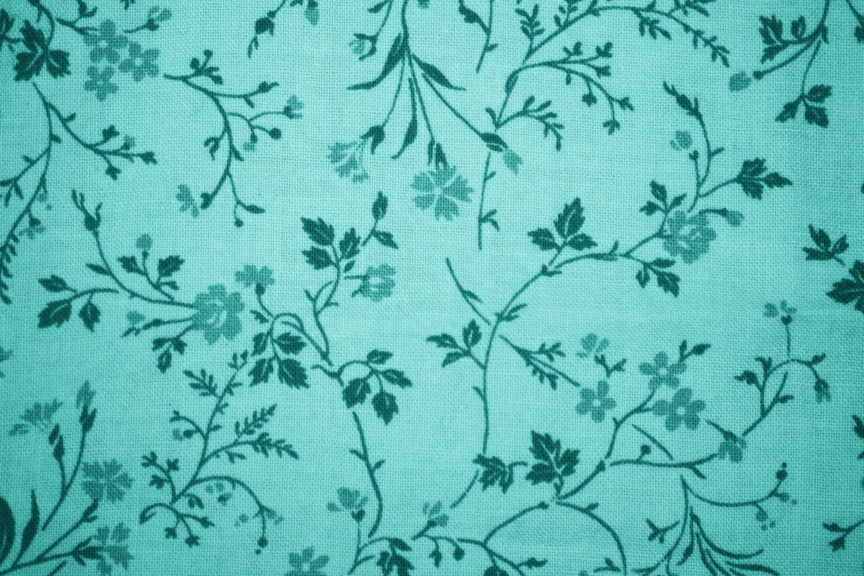 藍綠花卉圖案 壁紙 — 深綠色花卉藤蔓和花朵重複圖案的青綠色布料特寫。