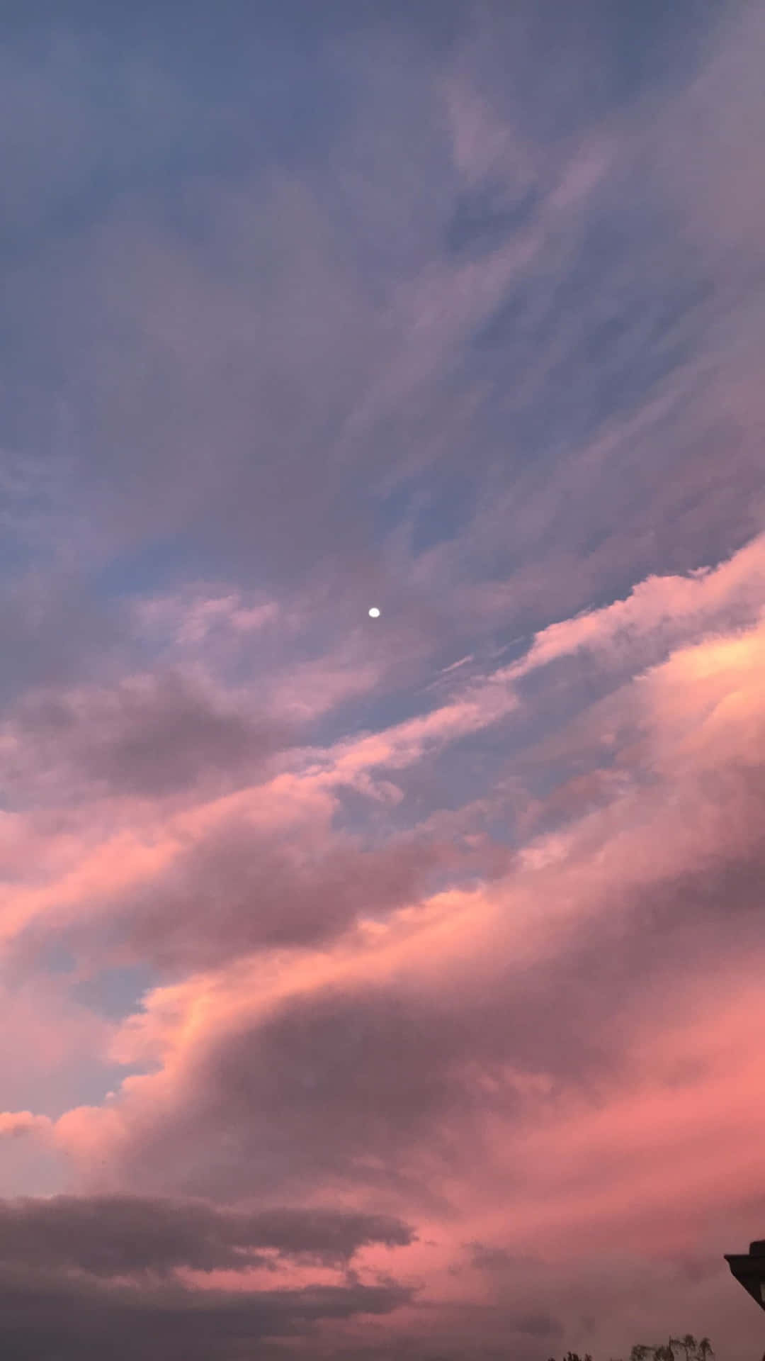 黃昏時的粉紅與紫色雲彩，上方有一輪小月亮