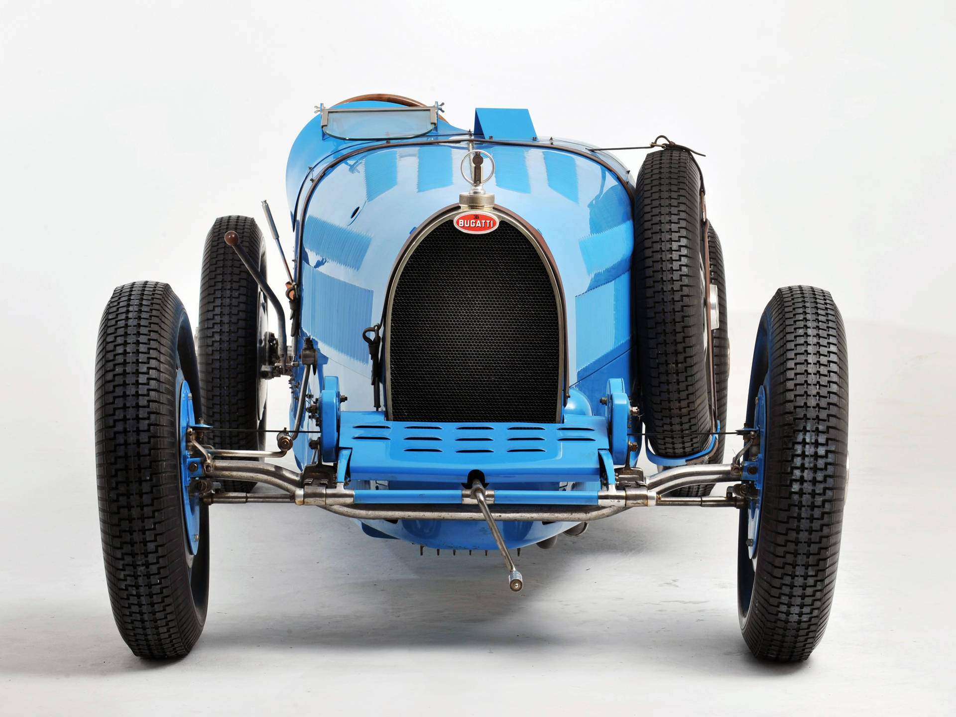 工作室中的復古藍色Bugatti賽車，外露底盤和備用輪胎。