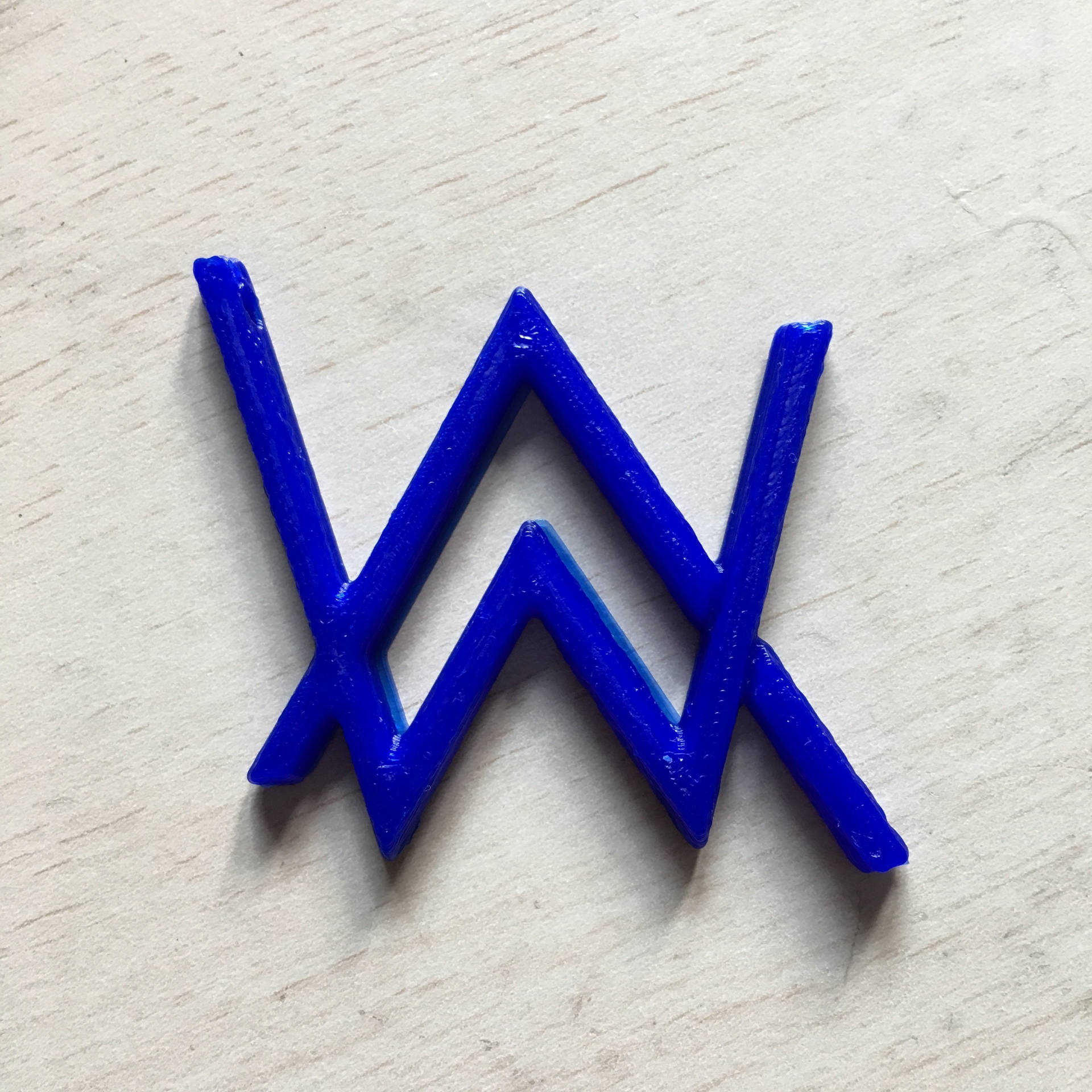 淺色木質表面上的藍色3D打印W標誌
