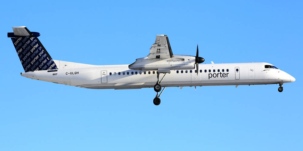 白色Porter Airlines飛機放下起落架在藍天中飛行