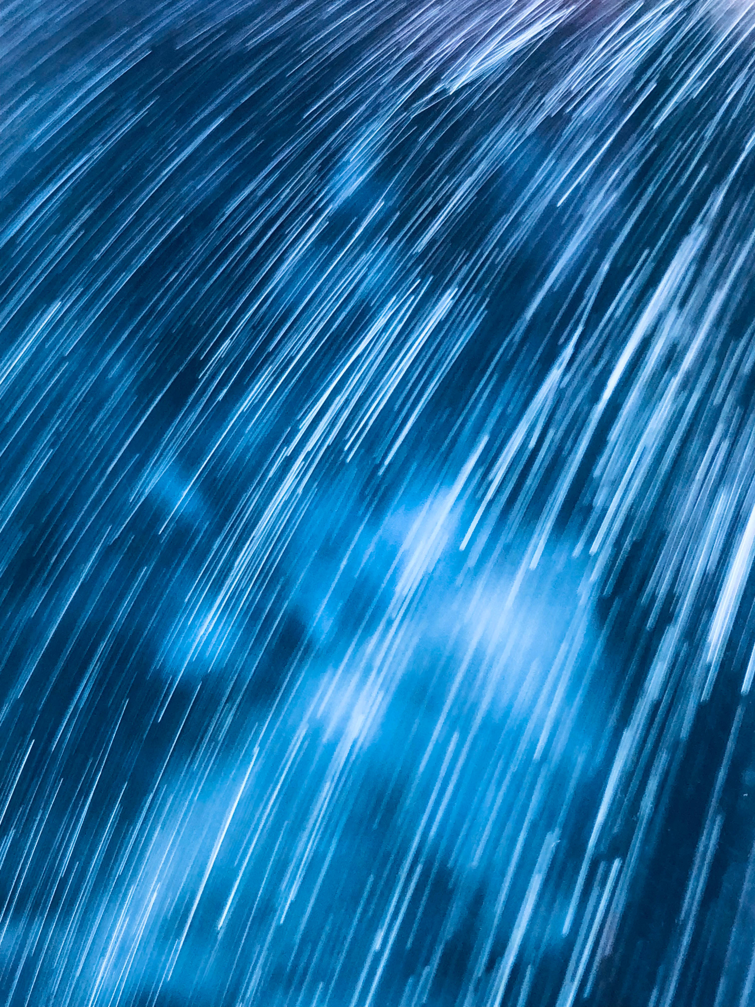 藍色iPhone美學雨滴藝術 壁紙 — 明亮的白色光線斜向流過深藍色紋理背景。