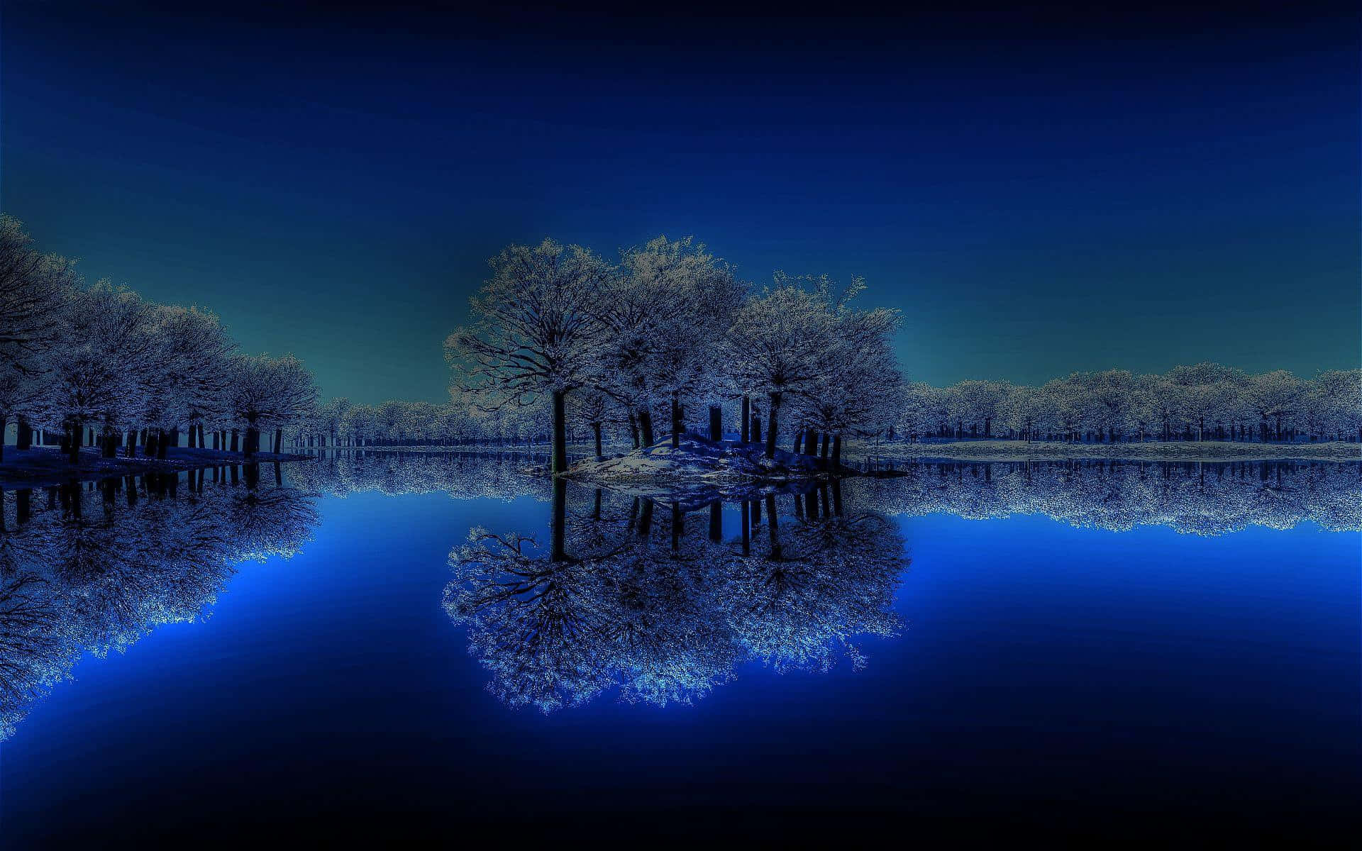 在黑暗的夜空下，平靜的藍色湖面反射出冰凍的樹木。
