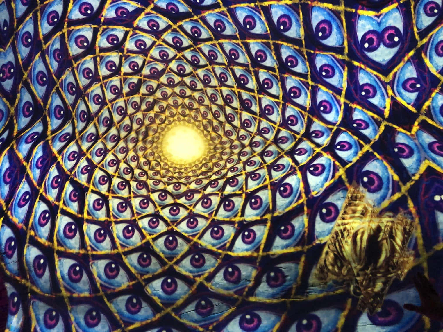 Otherworldly 桌布 壁紙 — 藍色和紫色孔雀眼圖案形成的迷人螺旋，匯聚到一個發光的黃色中心。