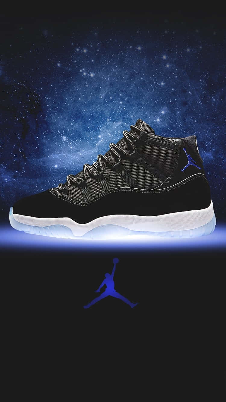 藍色喬丹11號「太空傑姆」配色 壁紙 — 一雙黑色Jordan 11運動鞋在星空宇宙背景下發出藍光，下方有一個藍色Jumpman標誌。