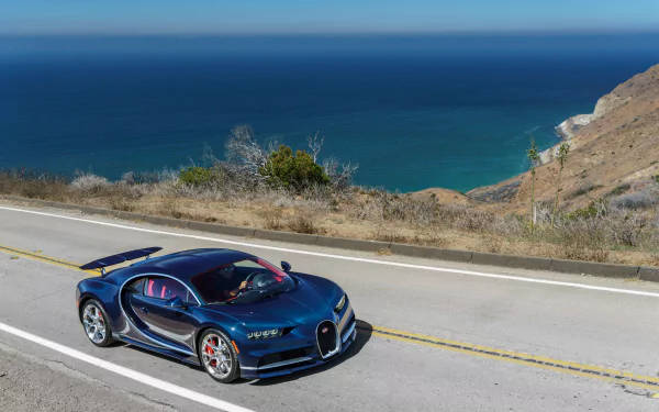 藍色Bugatti跑車在海景海岸公路上行駛。