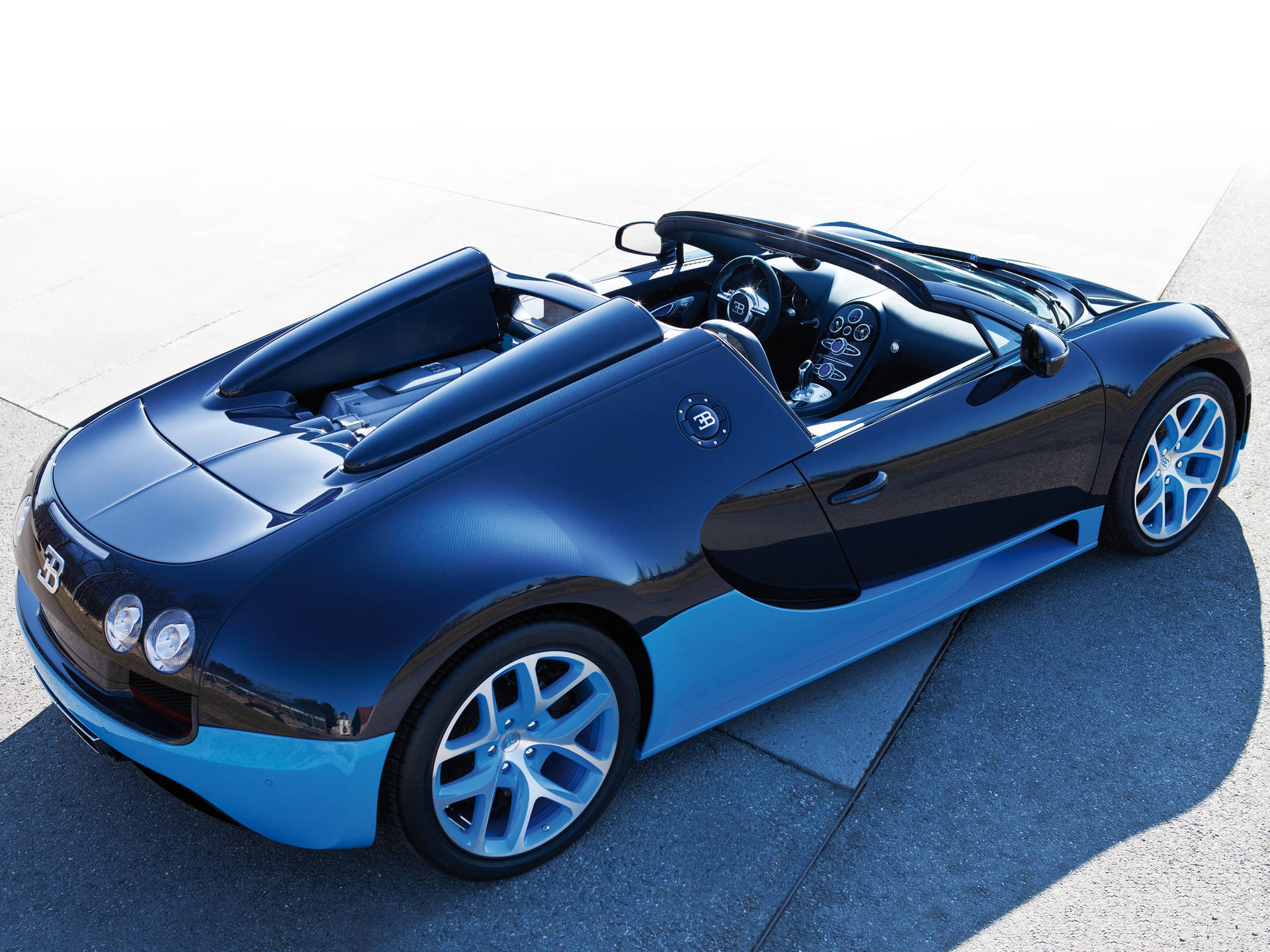 藍黑 Bugatti Veyron Super Sport 開篷車停泊在混凝土上。