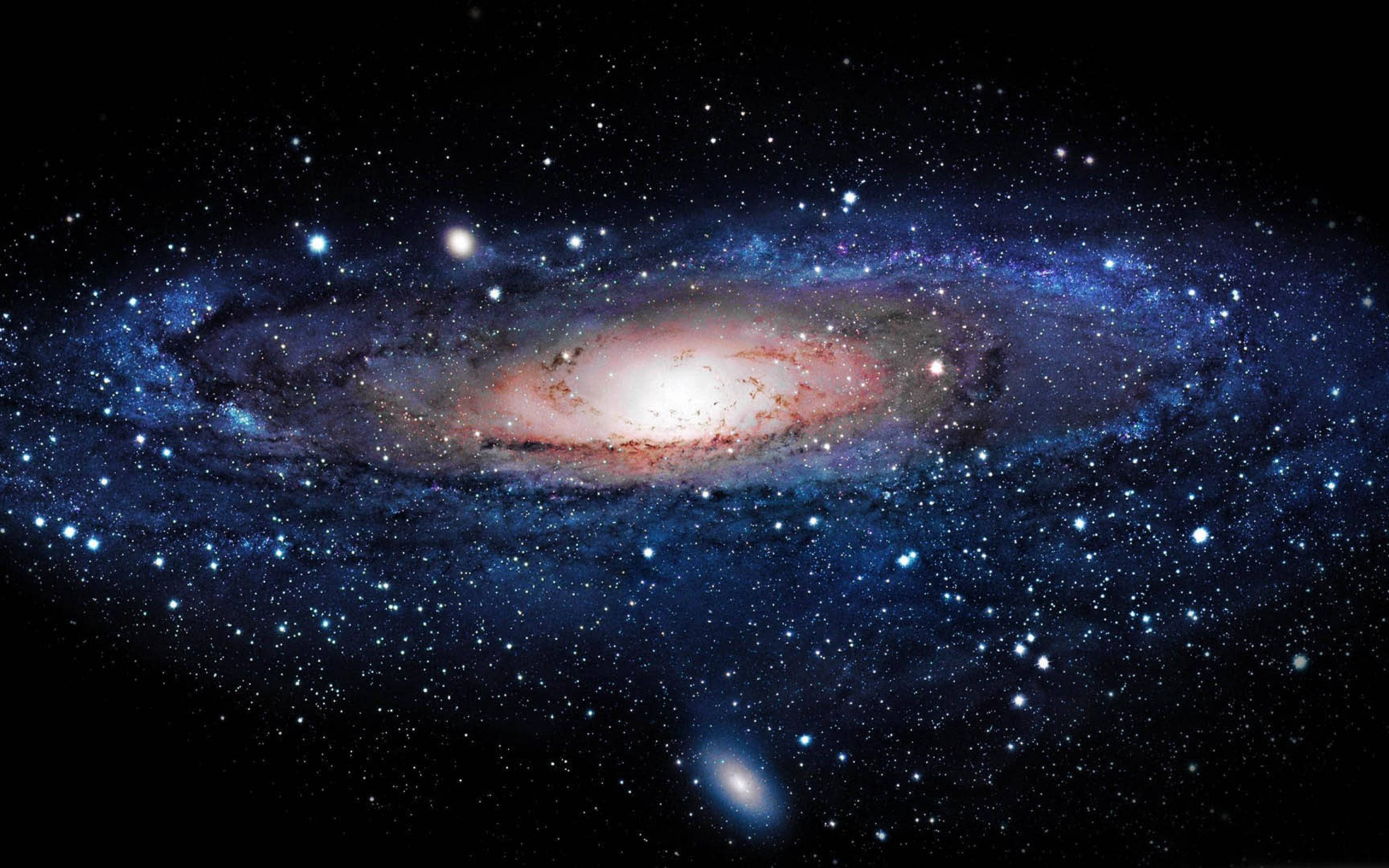 藍色星系中的仙女座星雲 壁紙 — 一個令人嘆為觀止的螺旋星系，在佈滿星星的黑色宇宙背景下散發出藍色和紅色的光芒。