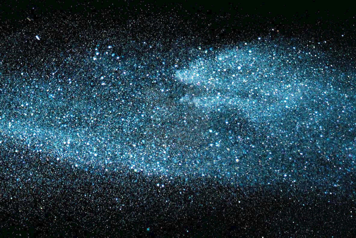充滿活力的藍色恆星和宇宙塵埃在黑暗的夜空中形成一個發光的星系。