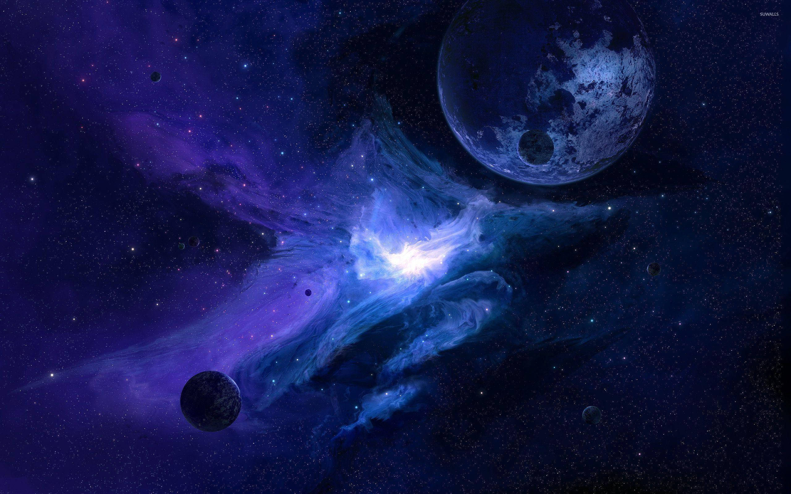 藍色星系與天體 壁紙 — 一個宇宙星雲發出鮮豔的藍色和紫色光芒，行星在佈滿星辰的虛空中飄移。