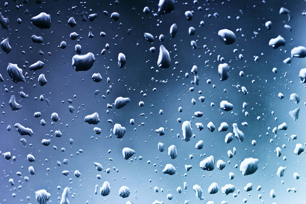 藍色水面上的倒影紋理 壁紙 — 雨滴依附在窗玻璃上，背景是清涼的藍色漸變天空。