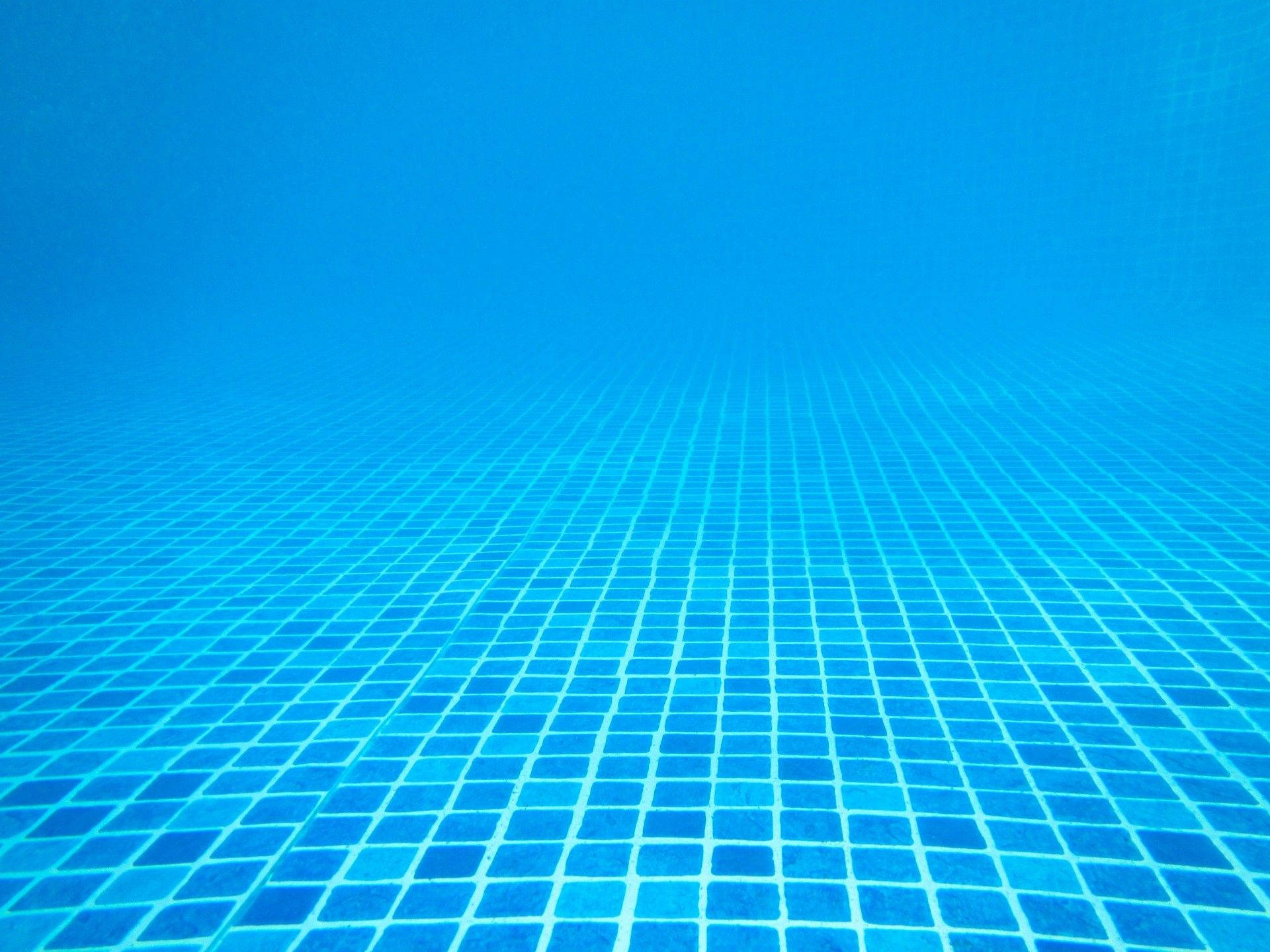 藍色瓷磚游泳池地板的水下視角。