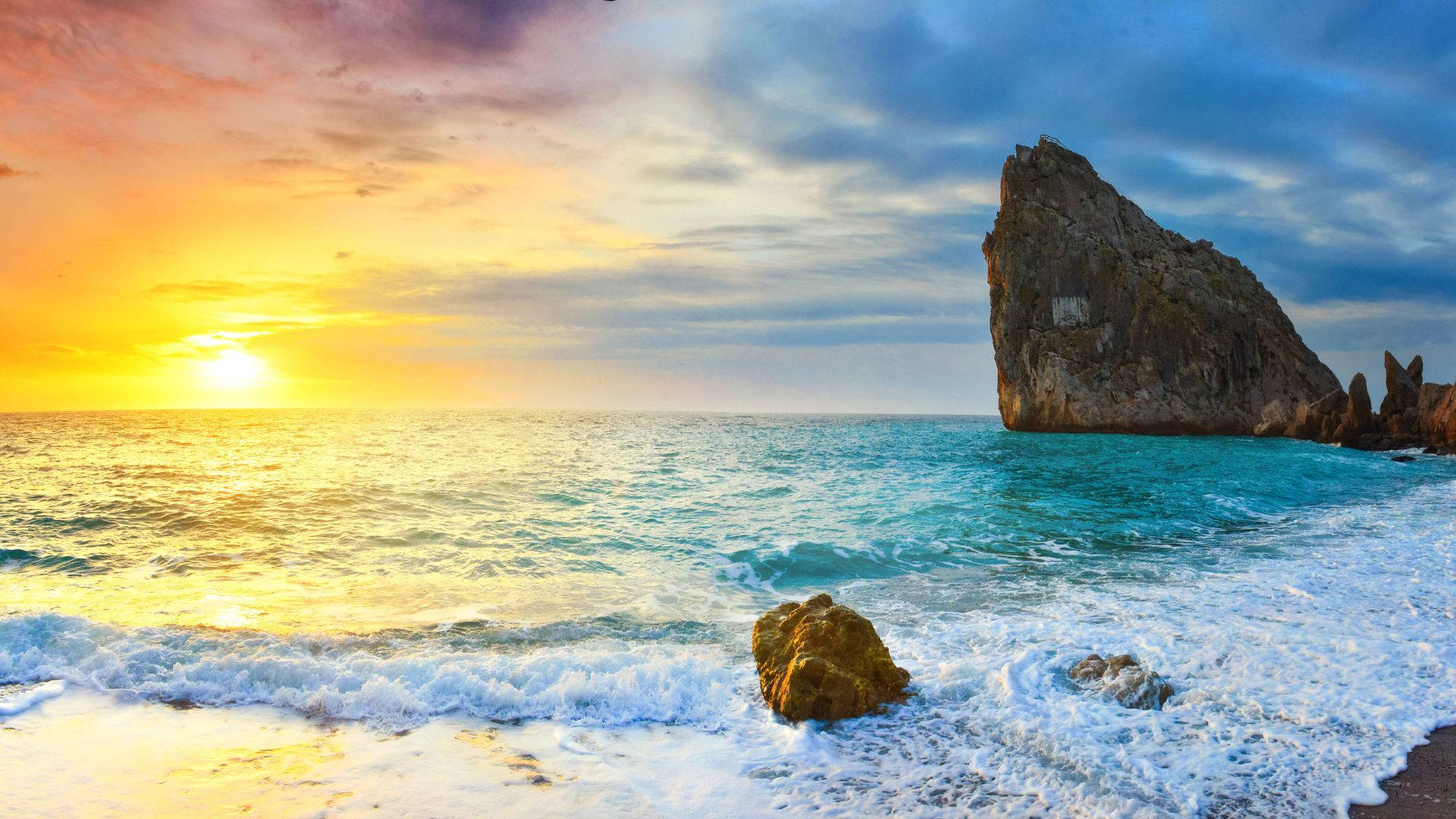 夕陽下的海洋，海浪拍打岩石海灘