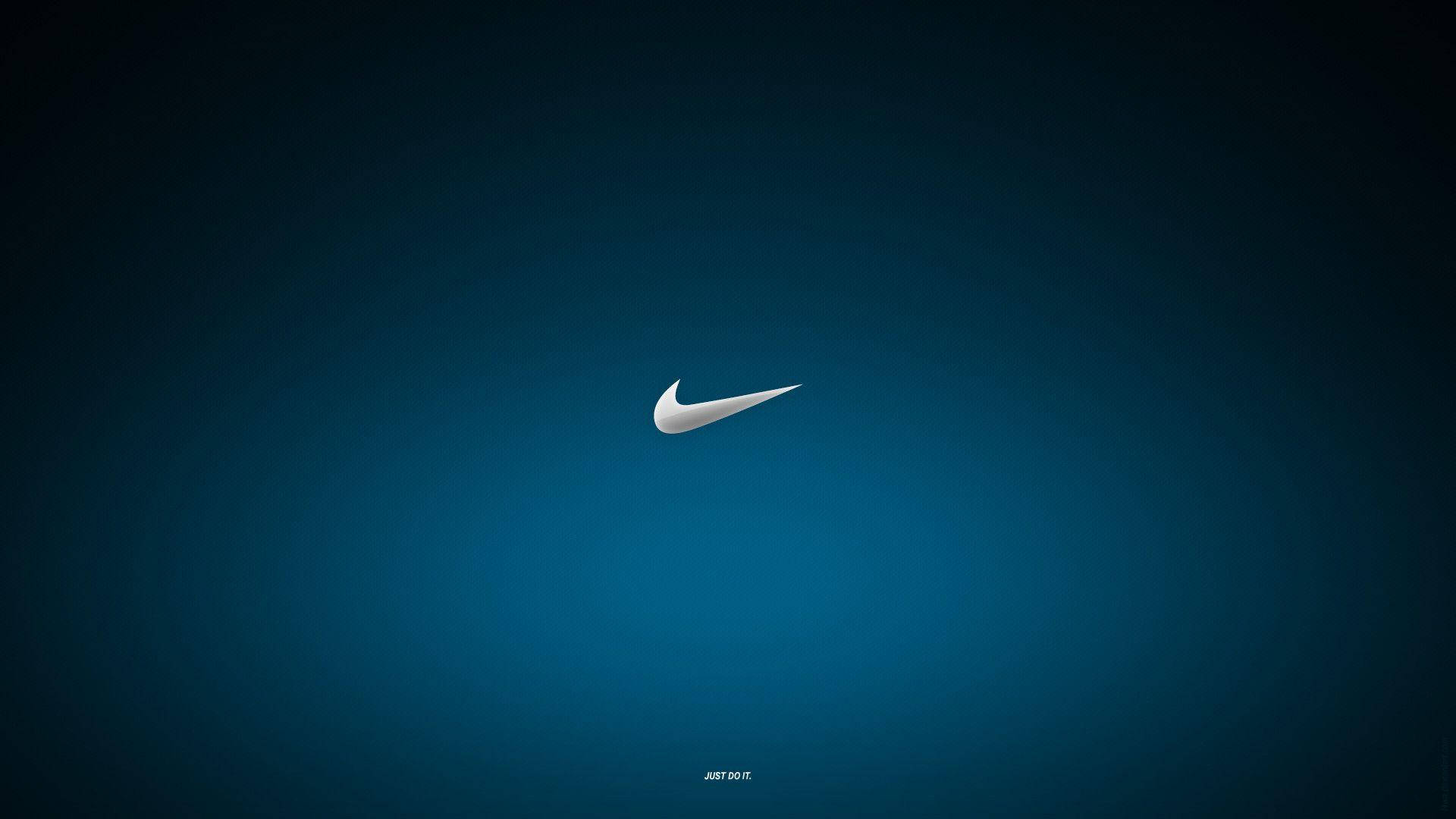 藍色漸層耐克標誌 壁紙 — 一個極簡的白色Nike swoosh標誌，居中放置在帶有微妙照明的漸變藍色背景上。