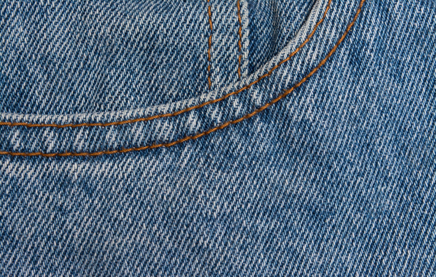 Denim 桌布 壁紙 — 藍色牛仔布料的特寫，橙色縫線勾勒出袋口縫線，顯示出紋理織法。