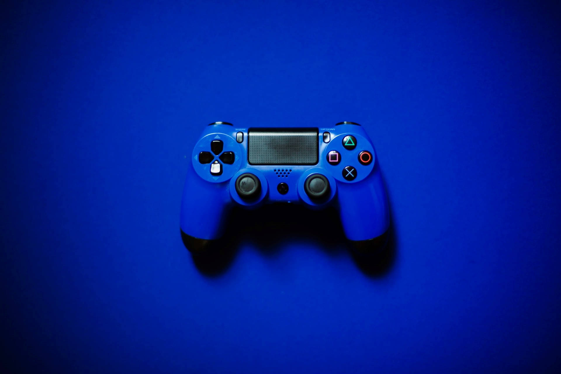 藍色美學Xbox遊戲控制器 壁紙 — 一個藍色PlayStation手掣放在純藍色背景中央，帶有柔和陰影。