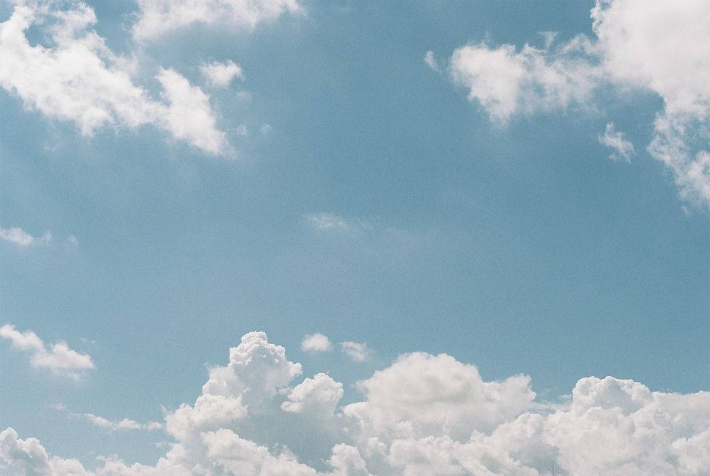 藍色美學雲朵桌面 壁紙 — 廣闊蔚藍的天空點綴著蓬鬆的白雲，懶洋洋地在頭頂飄過。