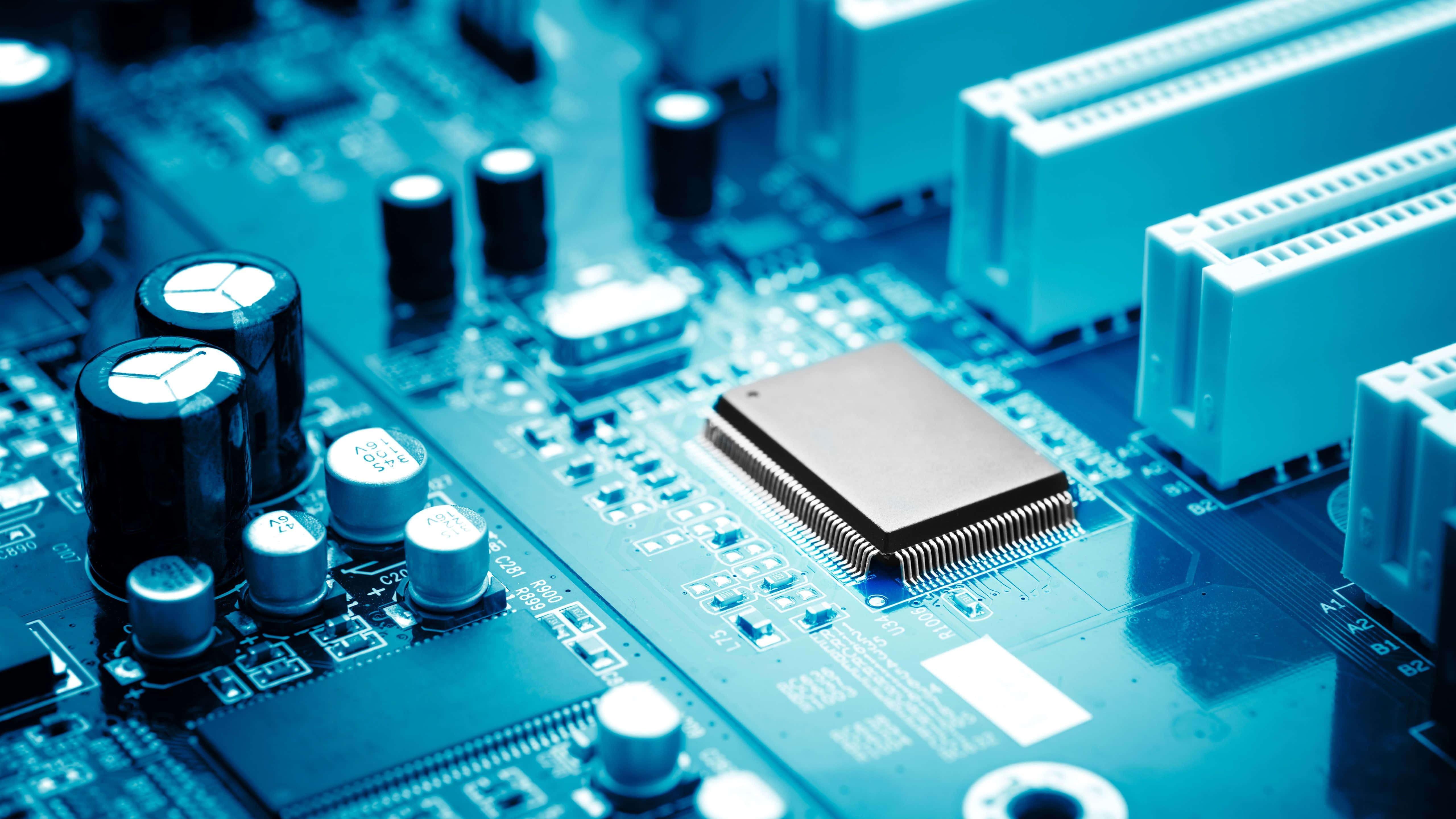Electronics 桌布 壁紙 — 藍色調電腦主機板的特寫，電容和中央晶片清晰對焦。