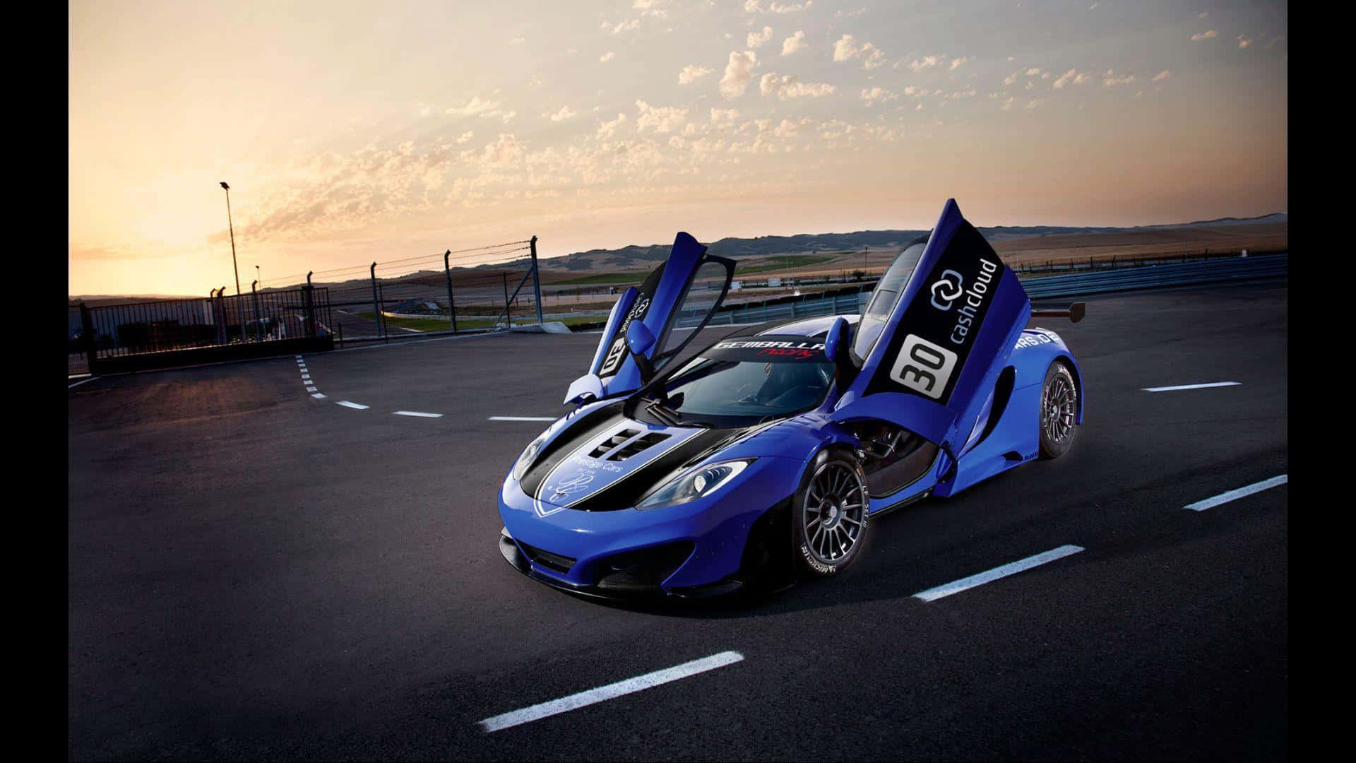 日落時分，藍色McLaren跑車在賽道上敞開車門。