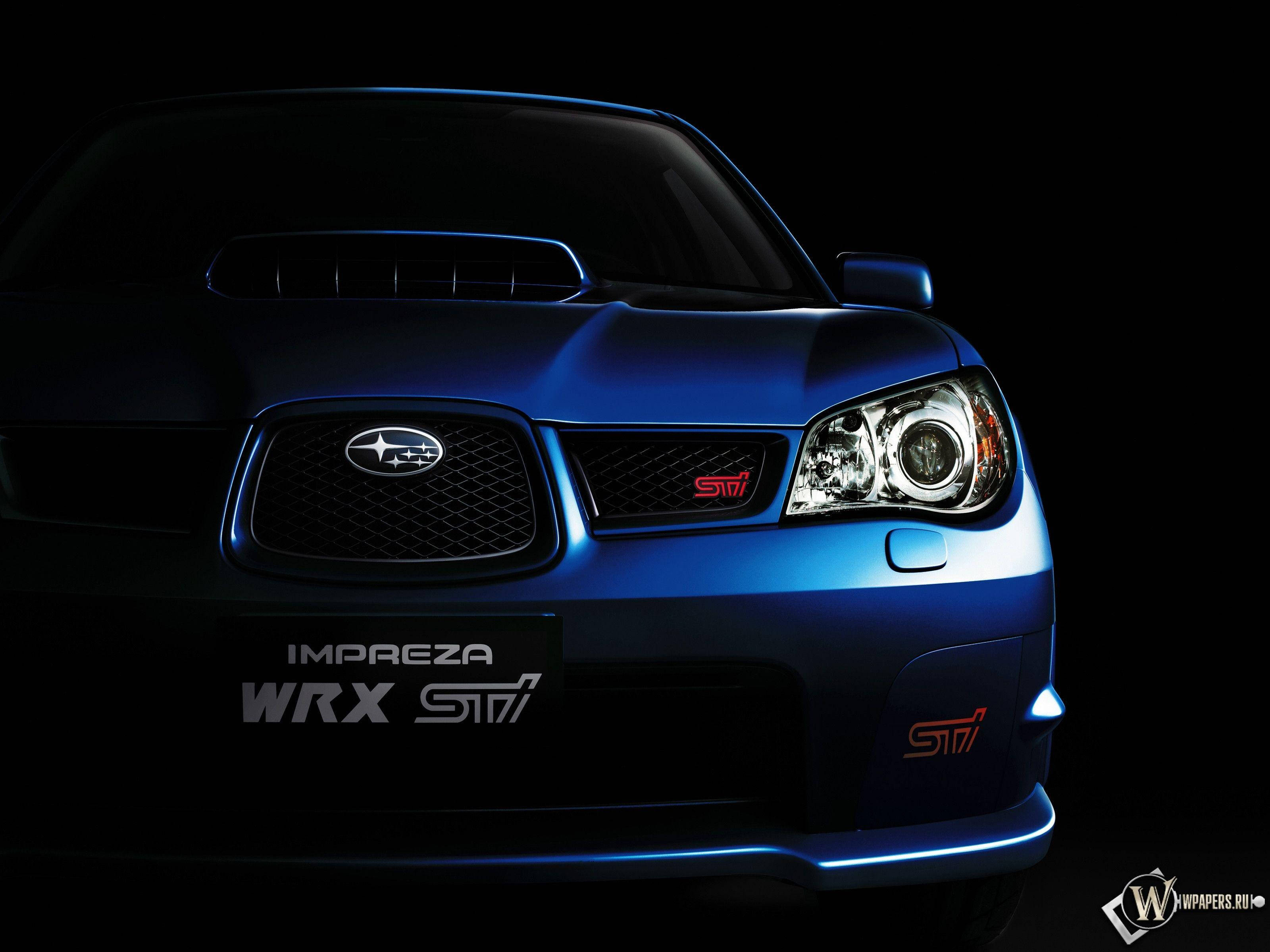 藍色金屬斯巴魯Impreza WRX ST7 壁紙 — 一輛時尚的藍色 Subaru Impreza WRX STI 在黑色背景下的戲劇性工作室燈光中閃耀。