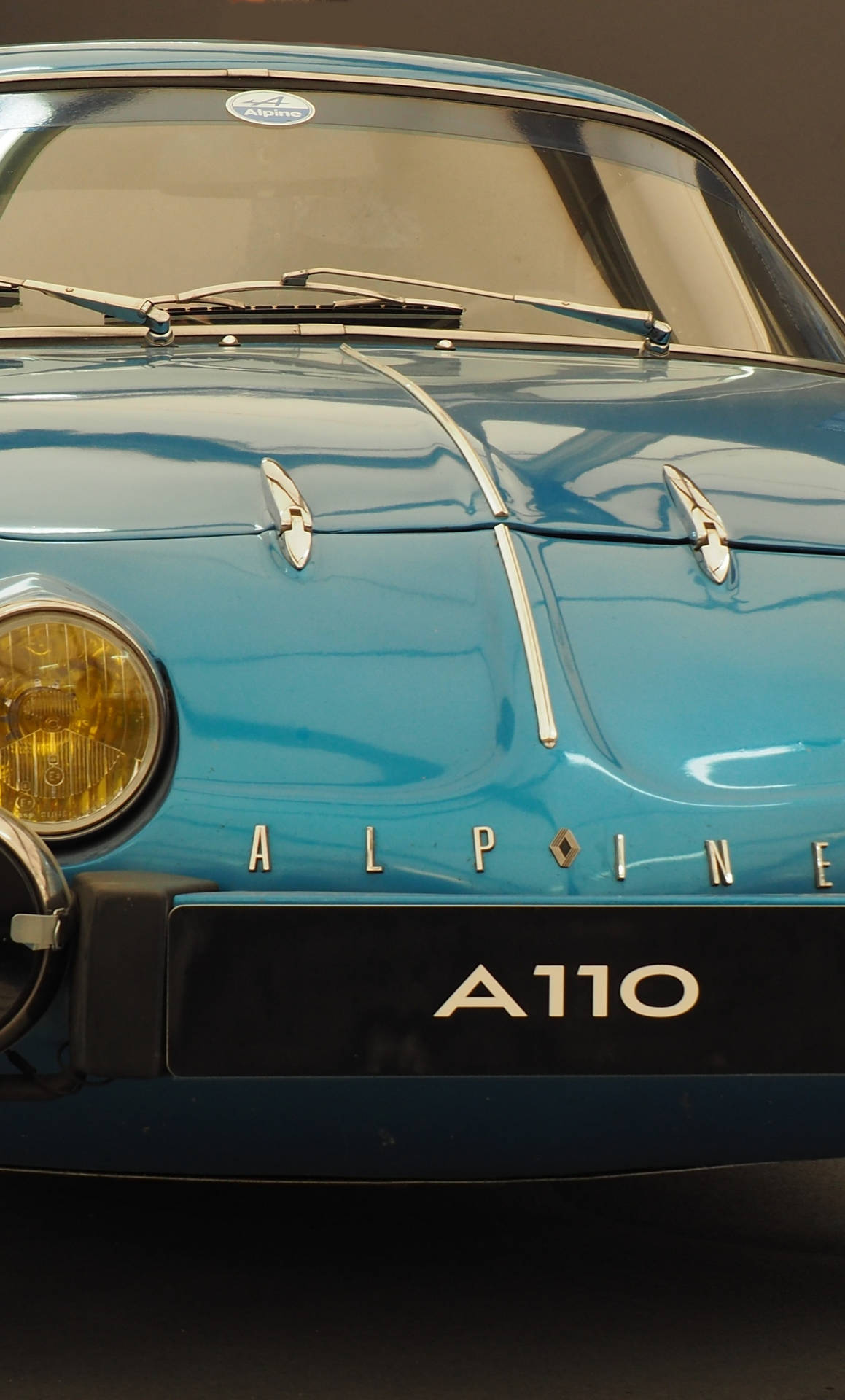 復古青綠色Alpine A110跑車正面視圖，帶有鍍鉻細節。