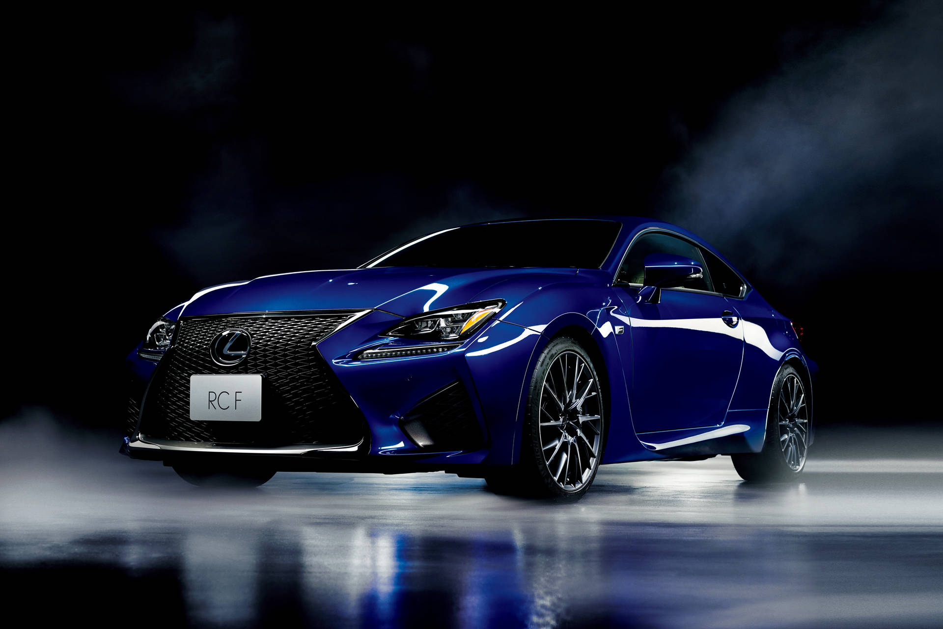 光澤藍色Lexus RCF跑車在反光地板上，煙霧繚繞的昏暗攝影棚。