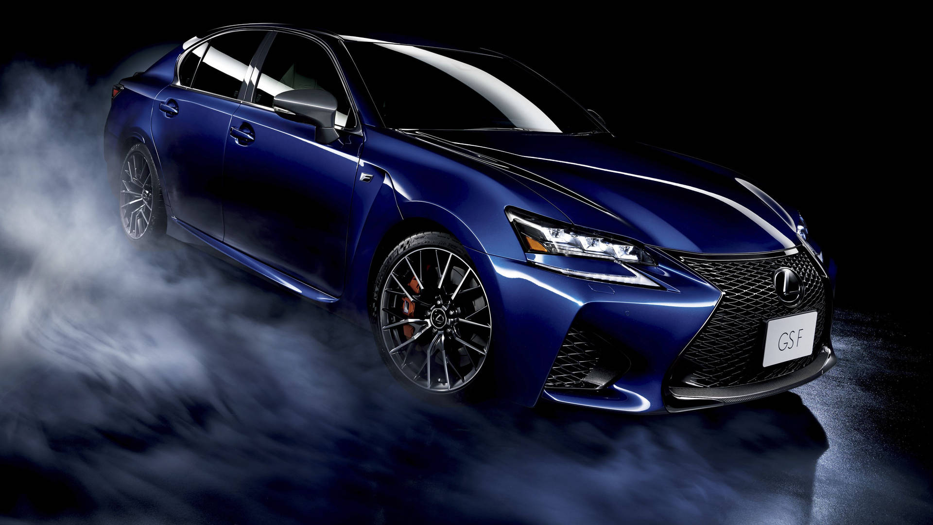藍色Lexus GS-F跑車在黑暗的攝影棚環境中被煙霧環繞。