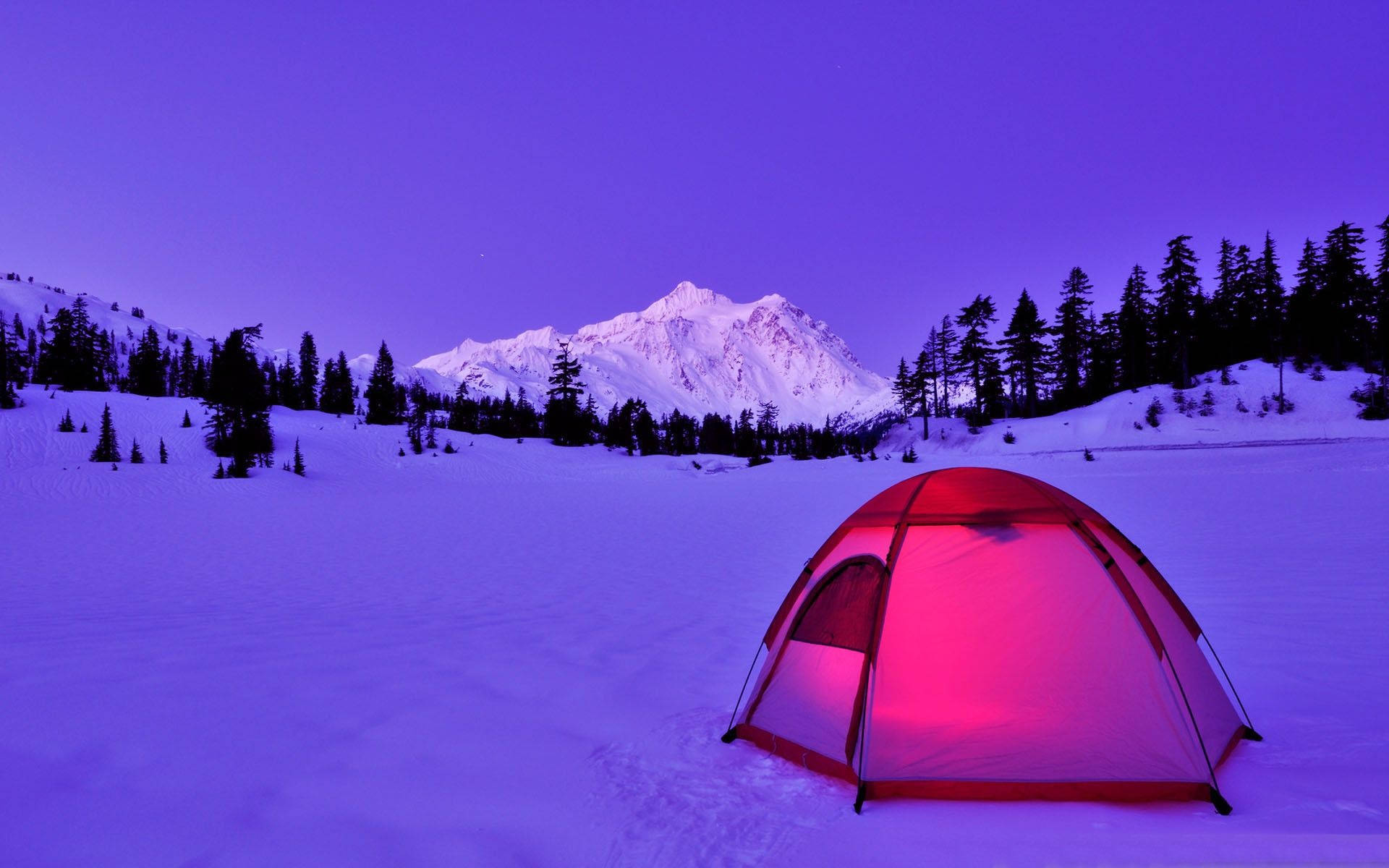紅色帳篷在暮色中的雪地山景中溫暖地發光。