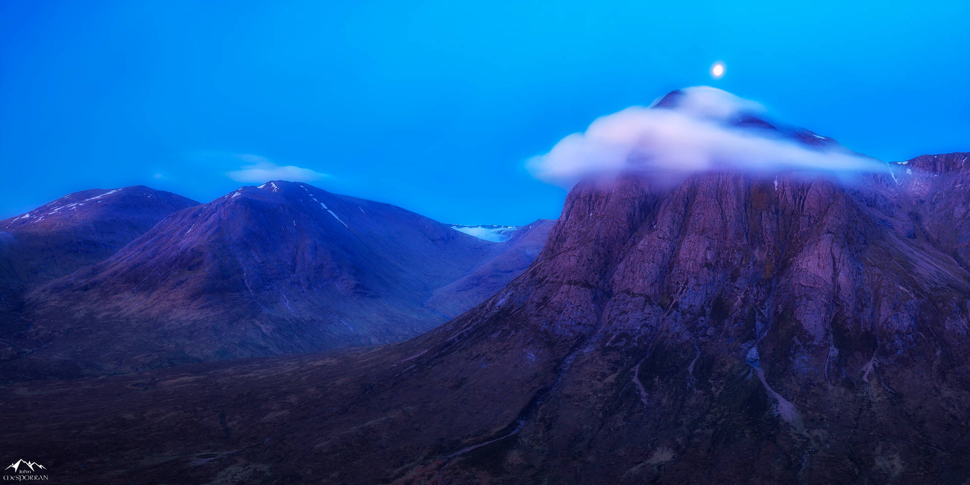 暮色中月光照耀的山峰頂端，雲朵飄動