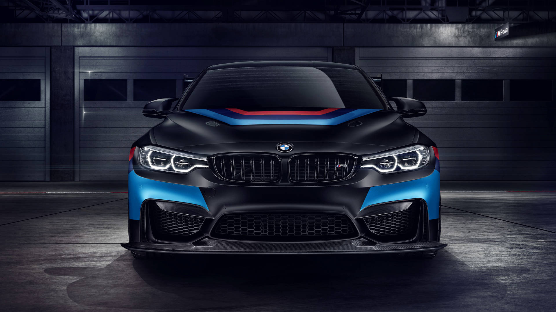 黑色BMW M2在黑暗車庫中帶有藍紅條紋