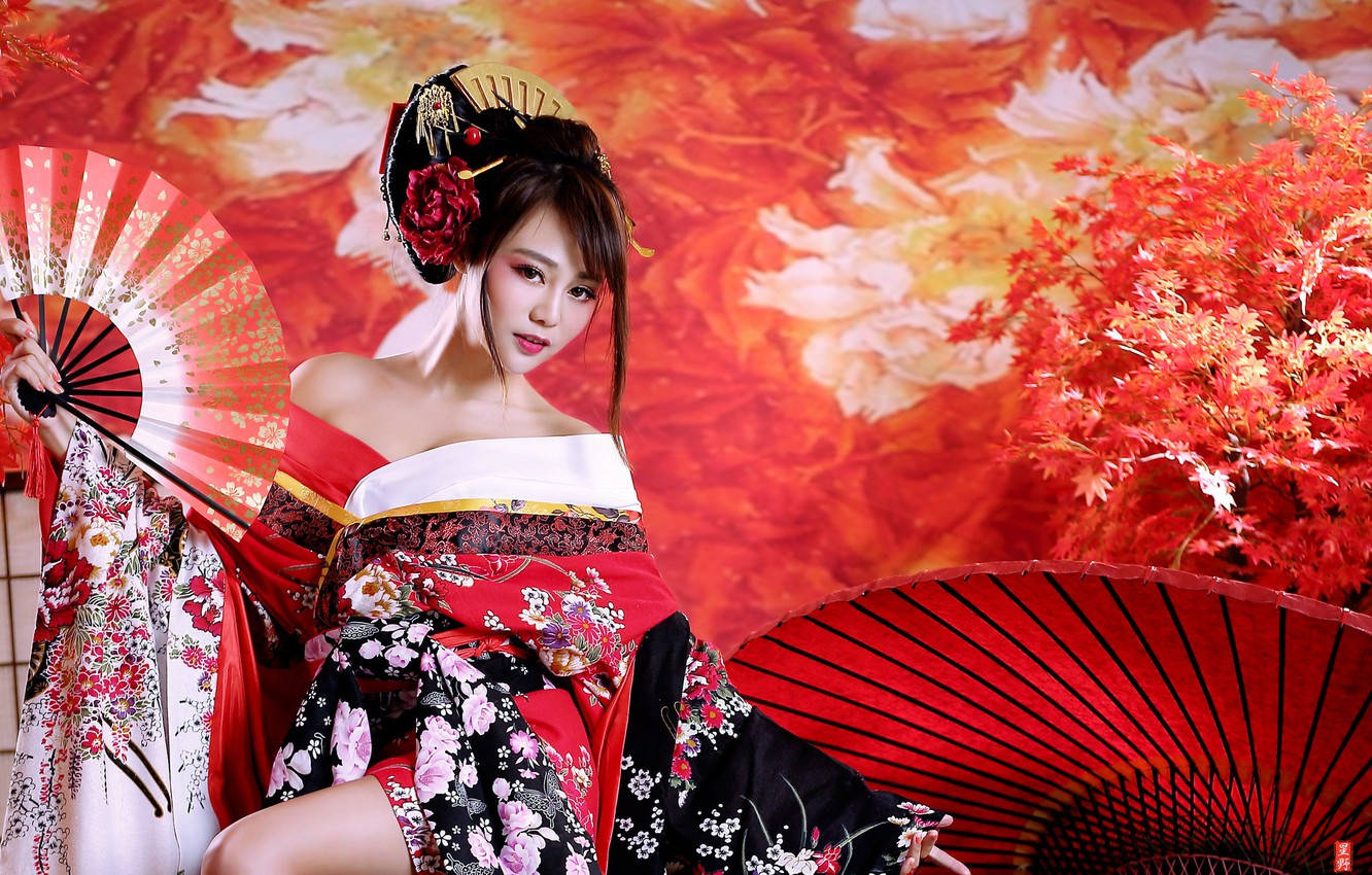 穿著傳統和服的女士手持扇子，背景是秋葉。