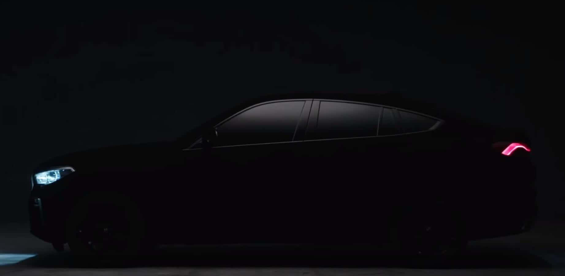 藝術之作：Vantablack 壁紙 — 一輛時尚的黑色汽車在黑暗的攝影棚背景下，車頭燈和尾燈發出光芒。